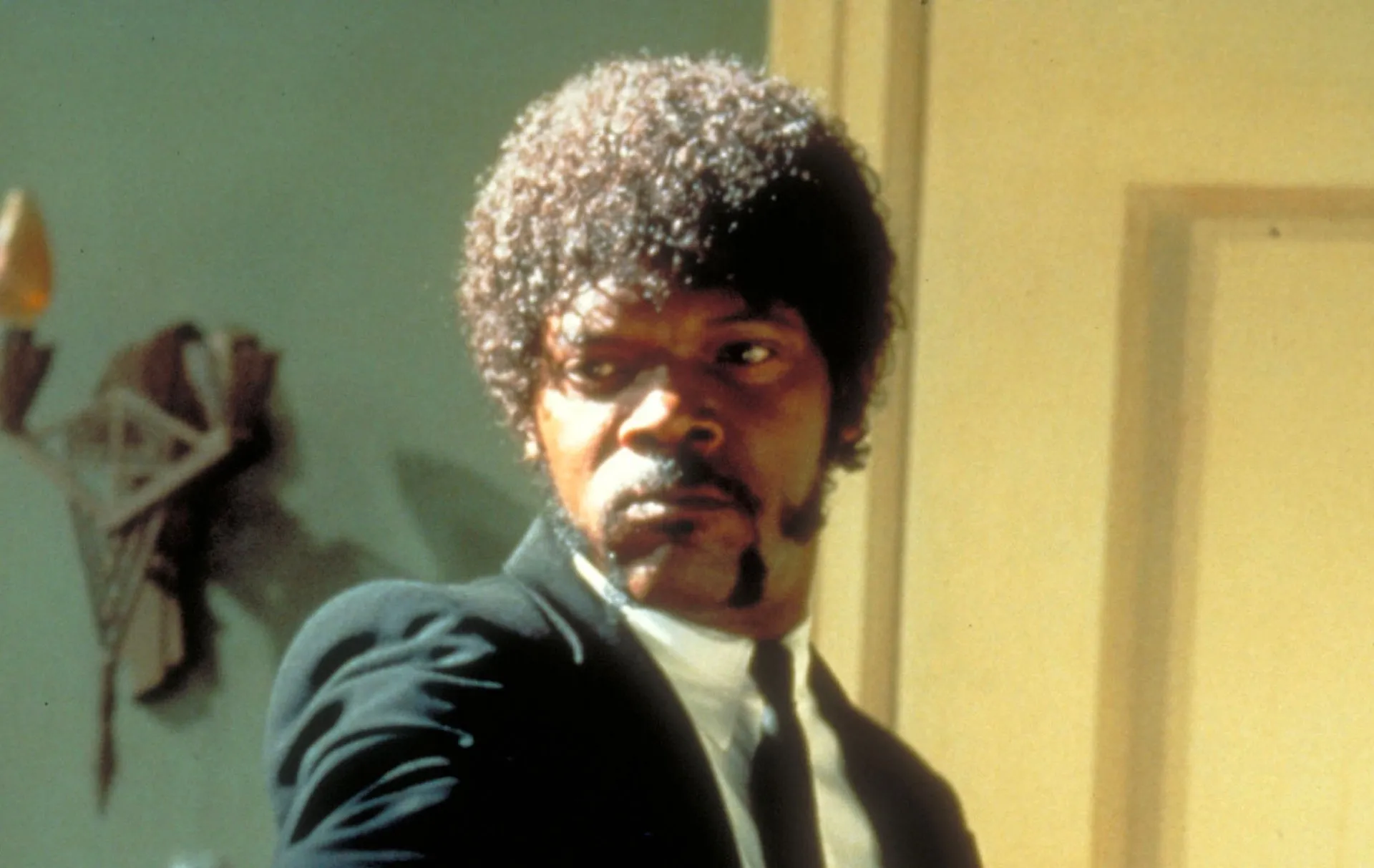Samuel L. Jackson mais jovem, com cabelo black power e um olhar intenso, em seus primeiros papéis.