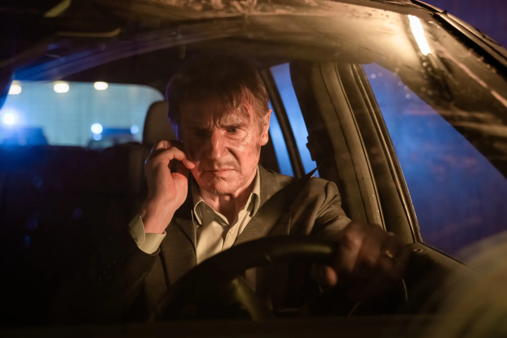 Liam Neeson mais velho, de cabelos brancos, em uma cena de ação do filme 'A Chamada'.