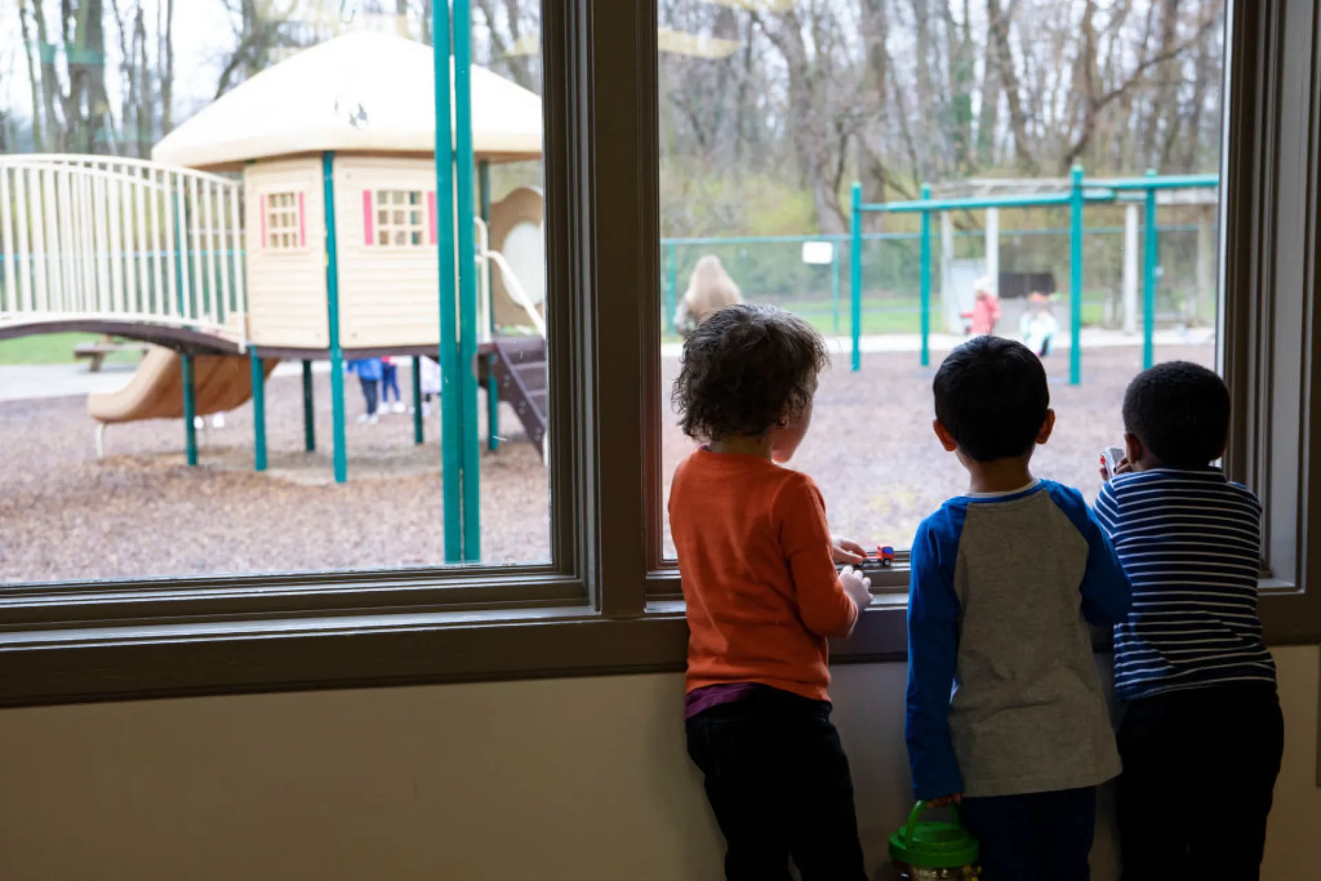 Pai e filho sentados juntos, o pai apontando para algo enquanto o filho olha com atenção e curiosidade.