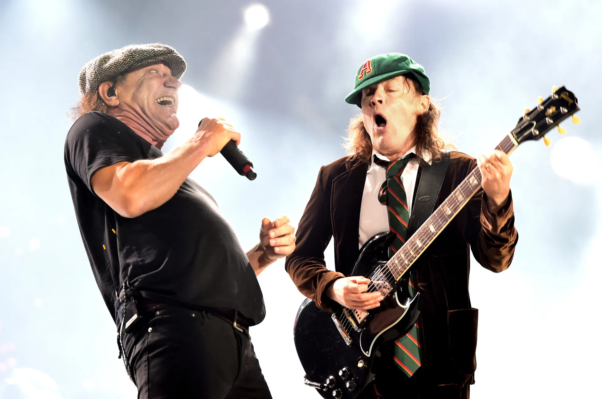 Malcolm Young, guitarrista do AC/DC, tocando sua guitarra com intensidade no palco.