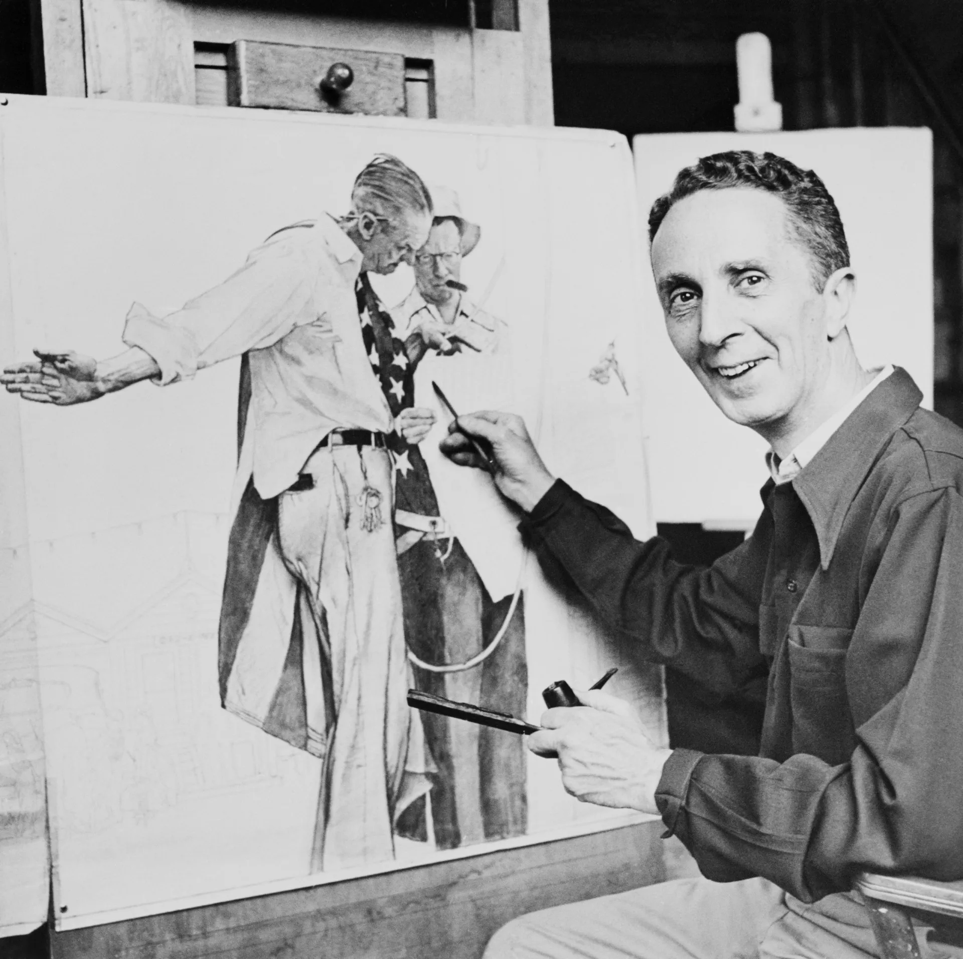 O pintor americano Norman Rockwell em seu estúdio, trabalhando em uma de suas obras.