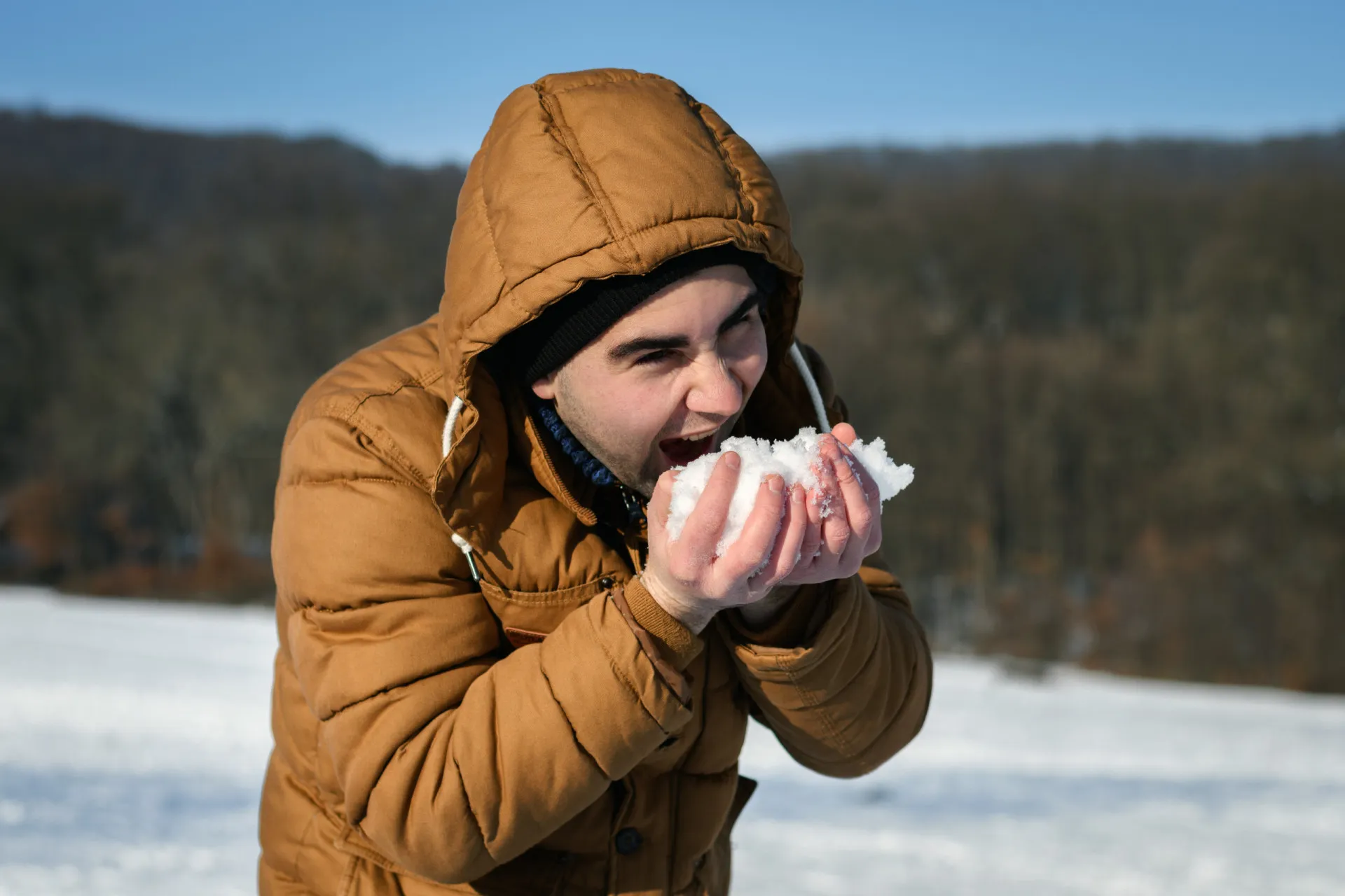 Mão enluvada segurando um punhado de neve fofa.