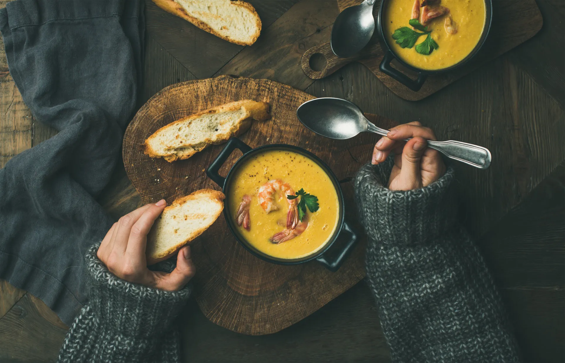 Pessoa oferecendo um pequeno pedaço de comida para outra que parece estar com frio.