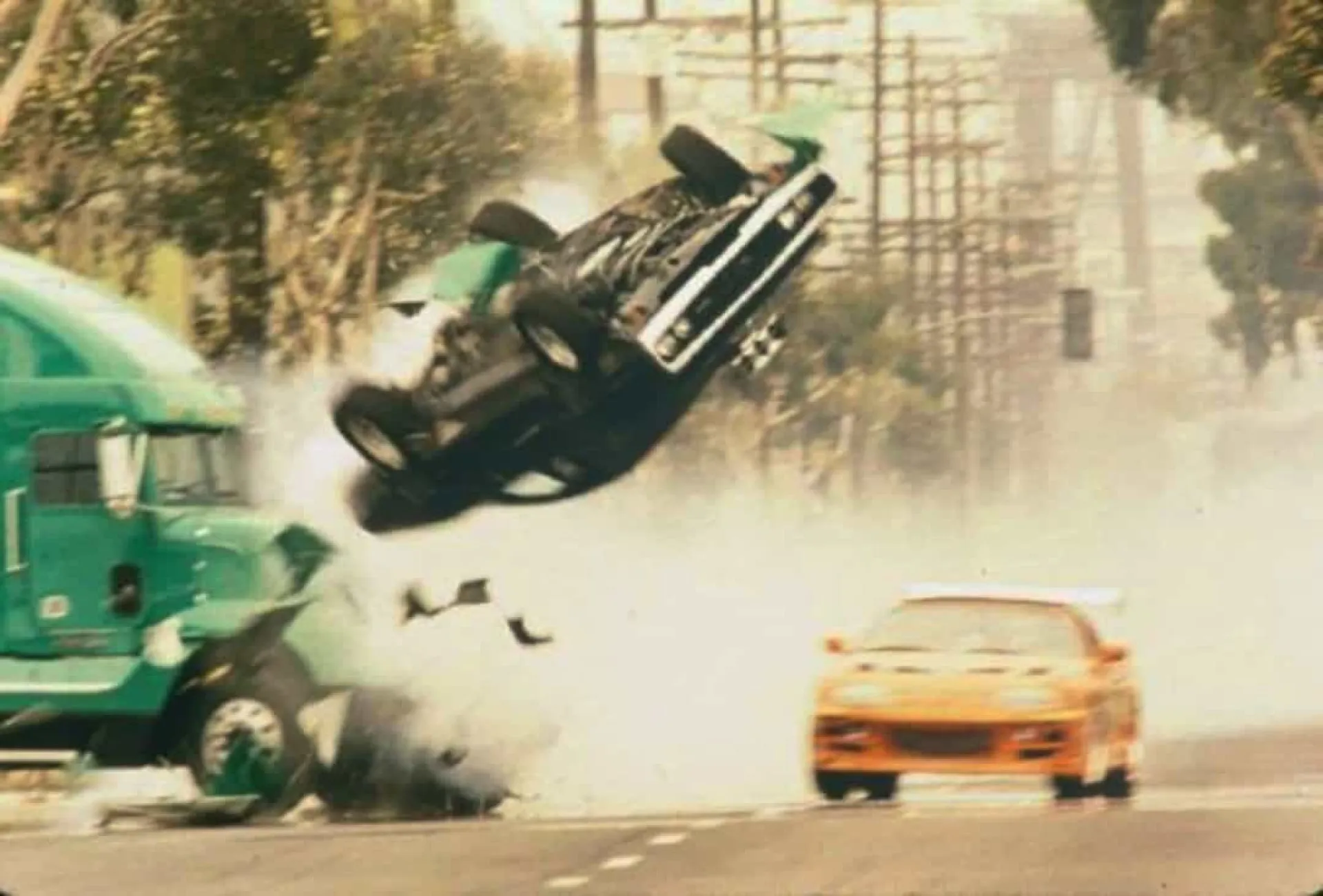Carros em alta velocidade fazendo uma curva perigosa durante uma perseguição em um filme.