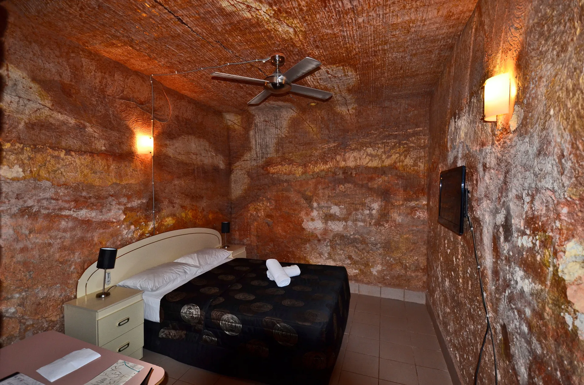 Interior de uma casa subterrânea moderna em Coober Pedy, com paredes de rocha natural.
