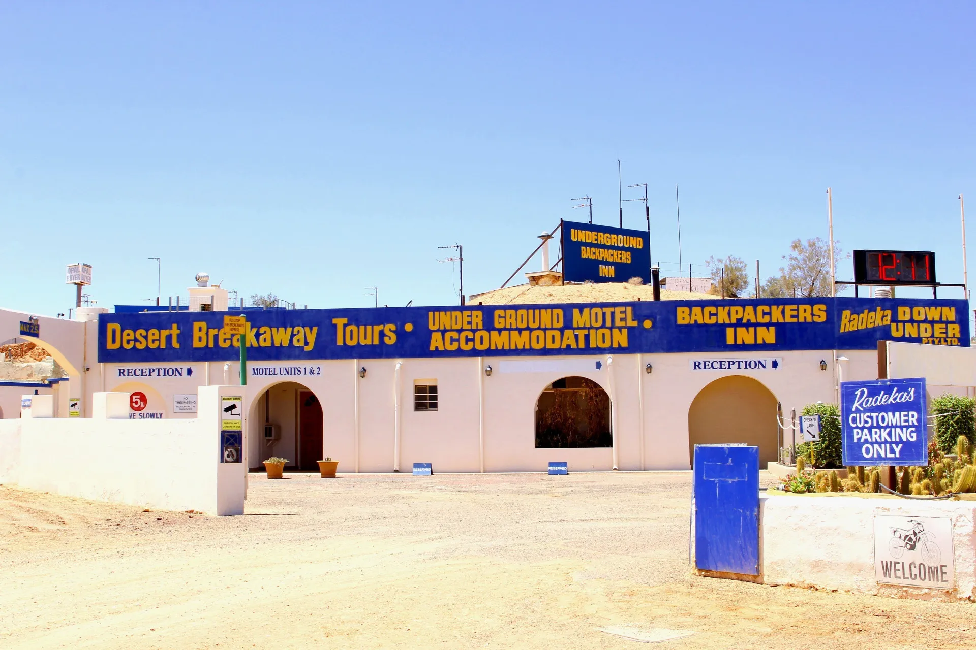 Entrada de uma casa subterrânea em Coober Pedy, com um carro estacionado do lado de fora.