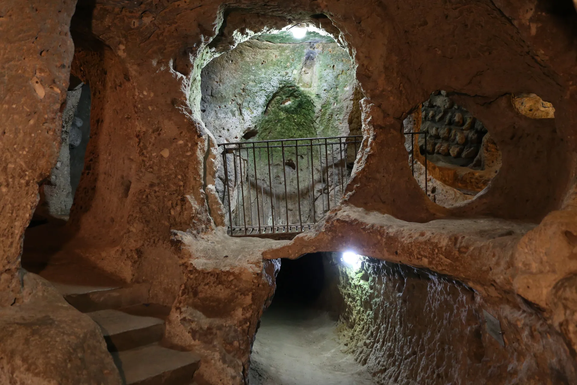 Turistas explorando os túneis e câmaras da cidade subterrânea de Derinkuyu.