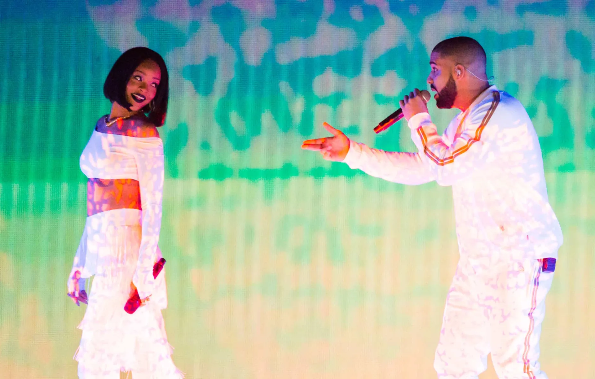Rihanna com uma expressão um pouco desconfortável ao lado de Drake.