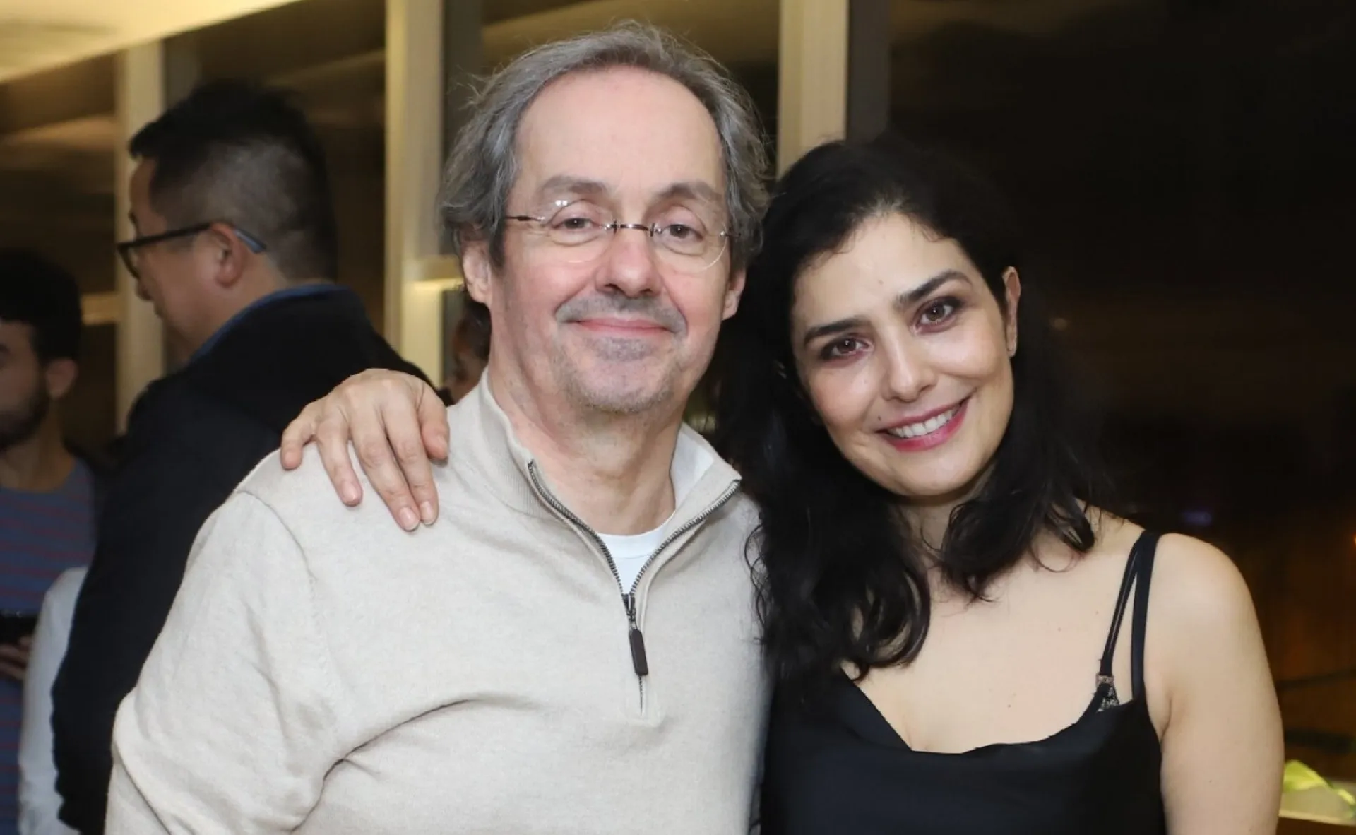 Letícia Sabatella e Daniel Dantas posando juntos em um evento, sorrindo.