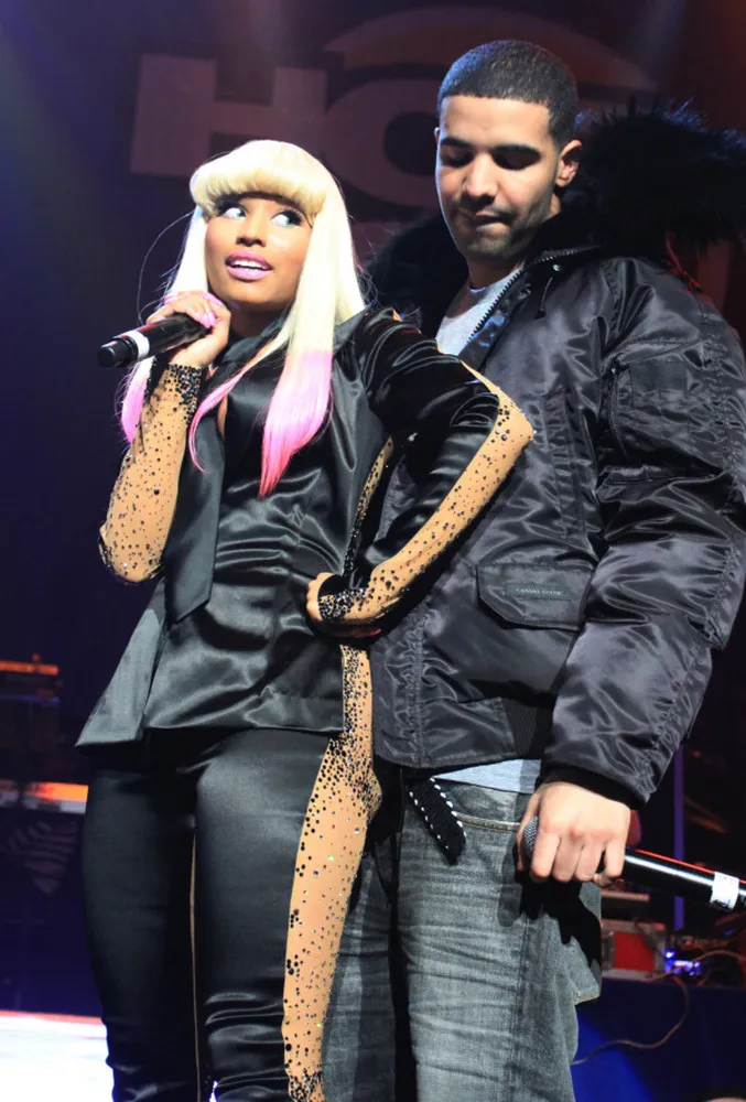 Drake e Nicki Minaj juntos em um evento, com olhares cúmplices.
