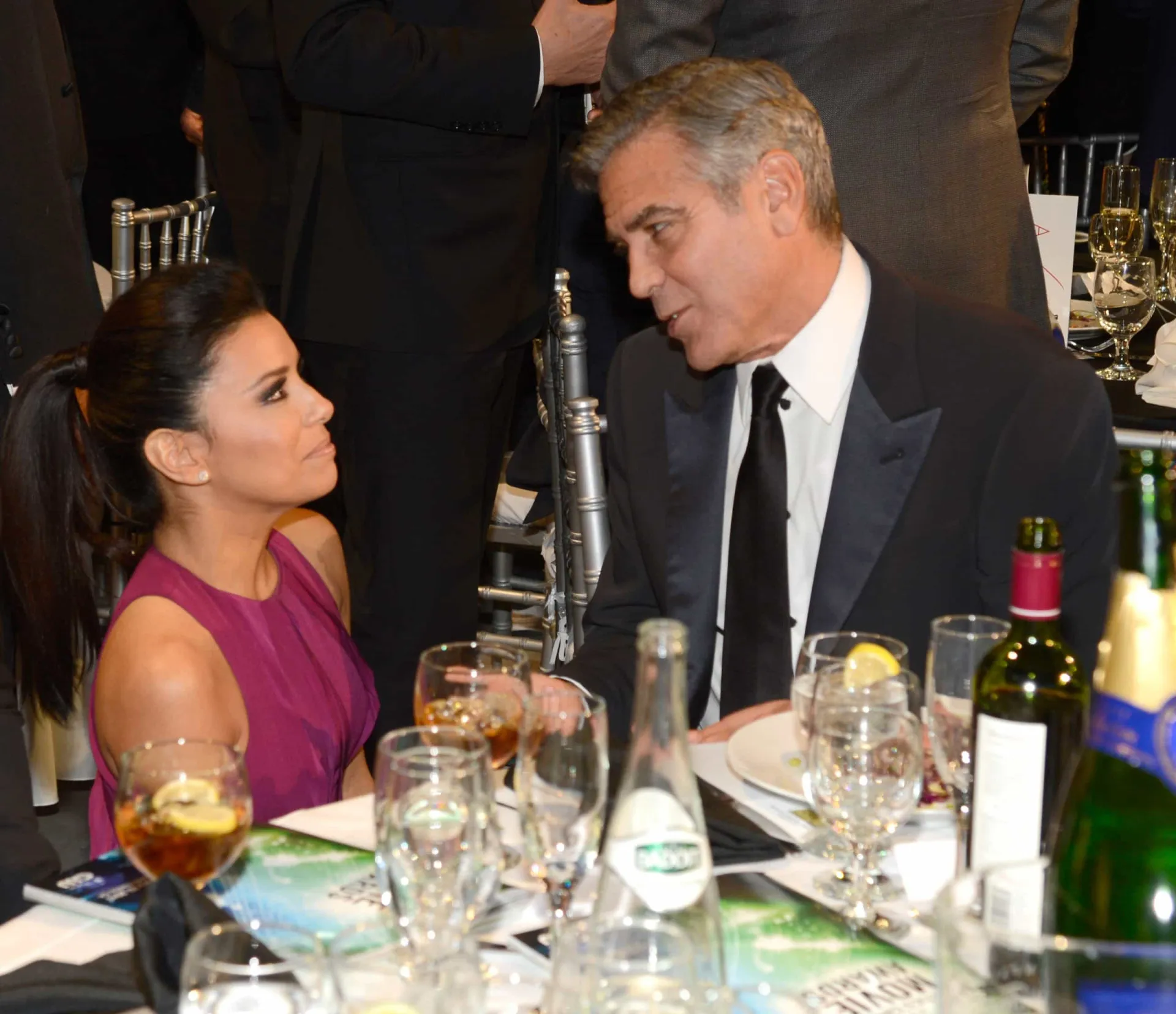 George Clooney com um sorriso charmoso e Eva Longoria posando com elegância.