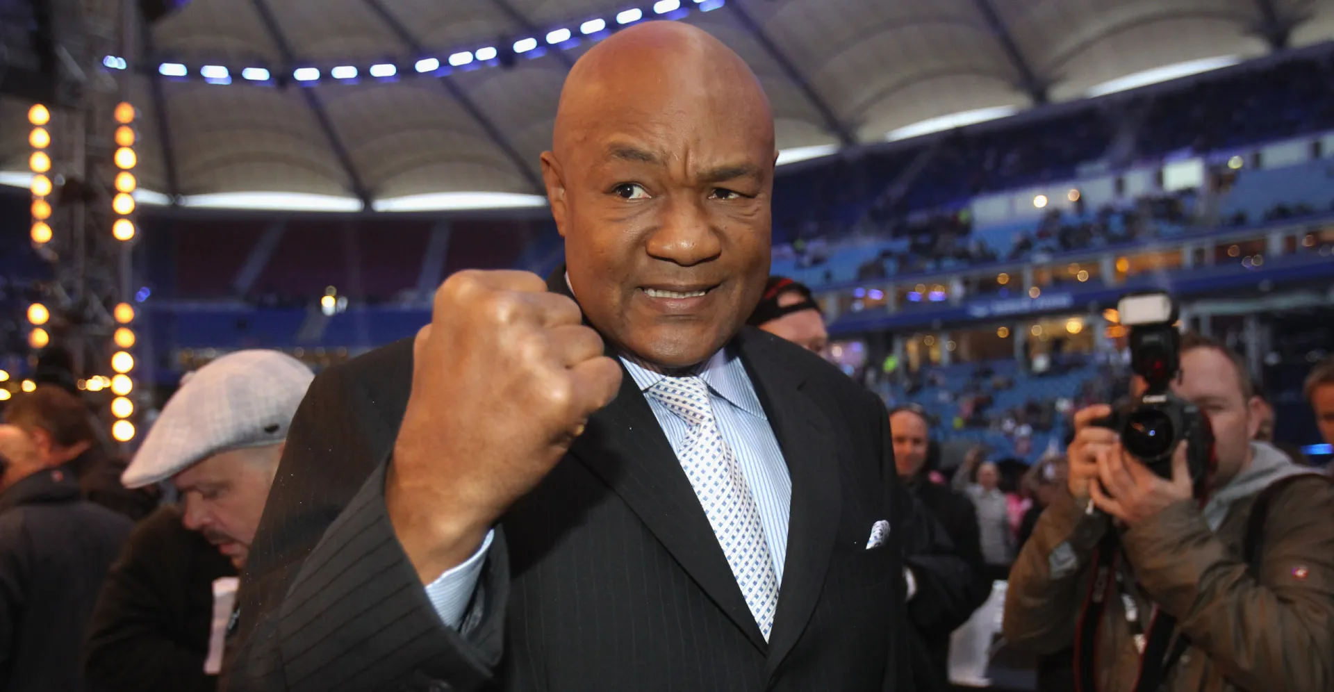 O ex-boxeador e empreendedor George Foreman, sorrindo e mostrando sua força.