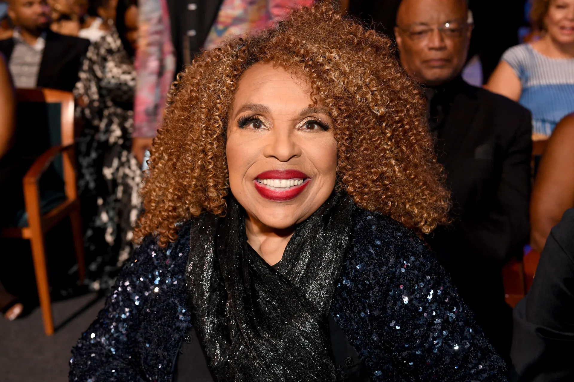 A lendária cantora Roberta Flack, em uma performance, com os olhos fechados e sentindo a música.