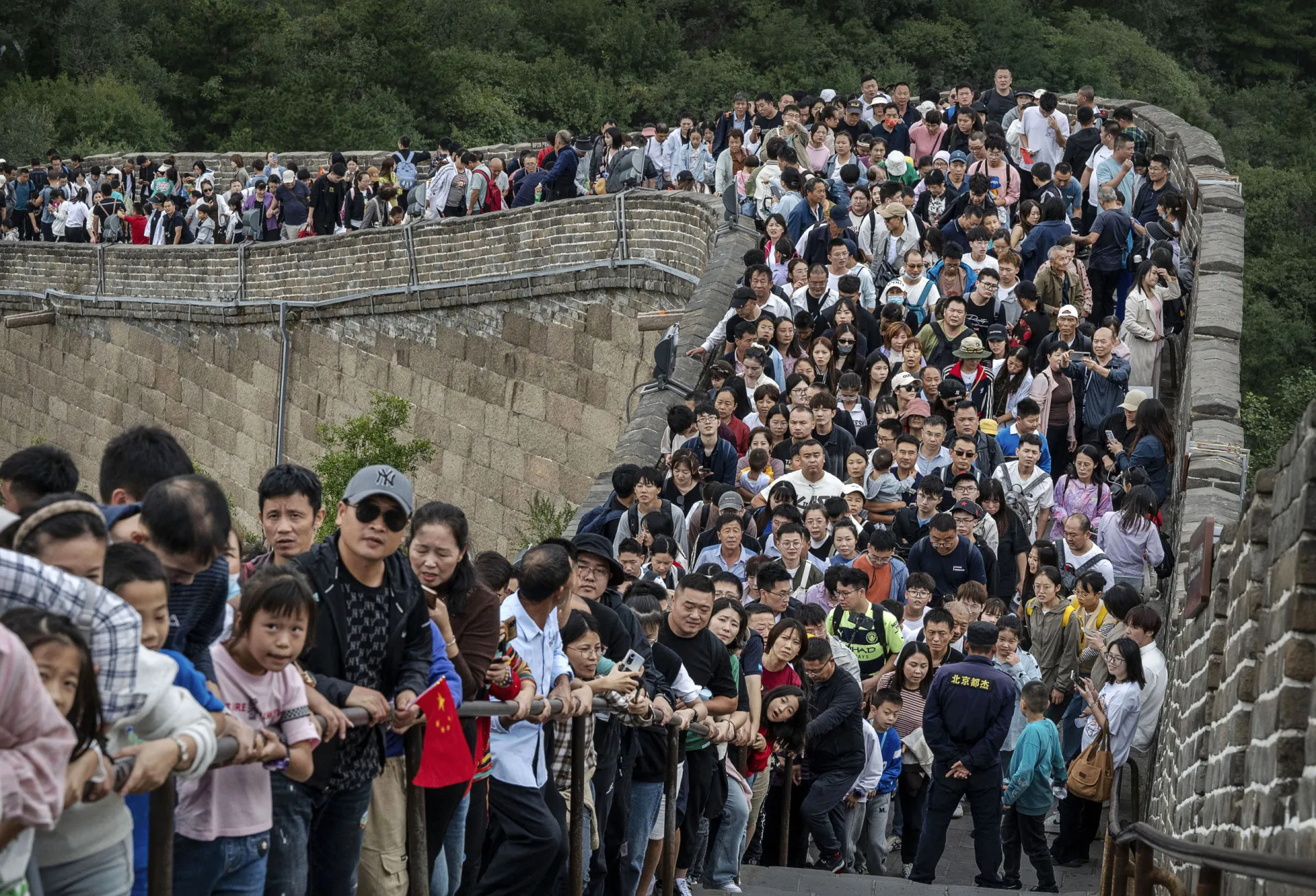 Pessoas atravessando uma faixa de pedestres em uma grande cidade chinesa.