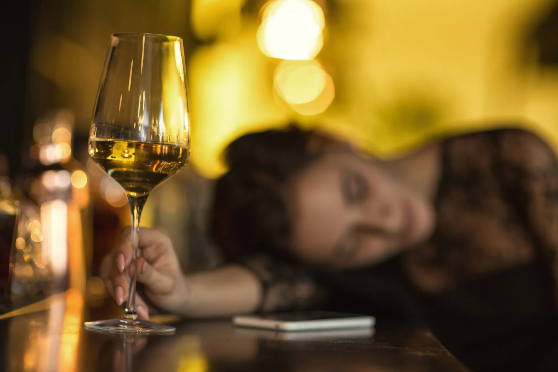 Um jovem olhando para uma prateleira de bebidas alcoólicas com dúvida.