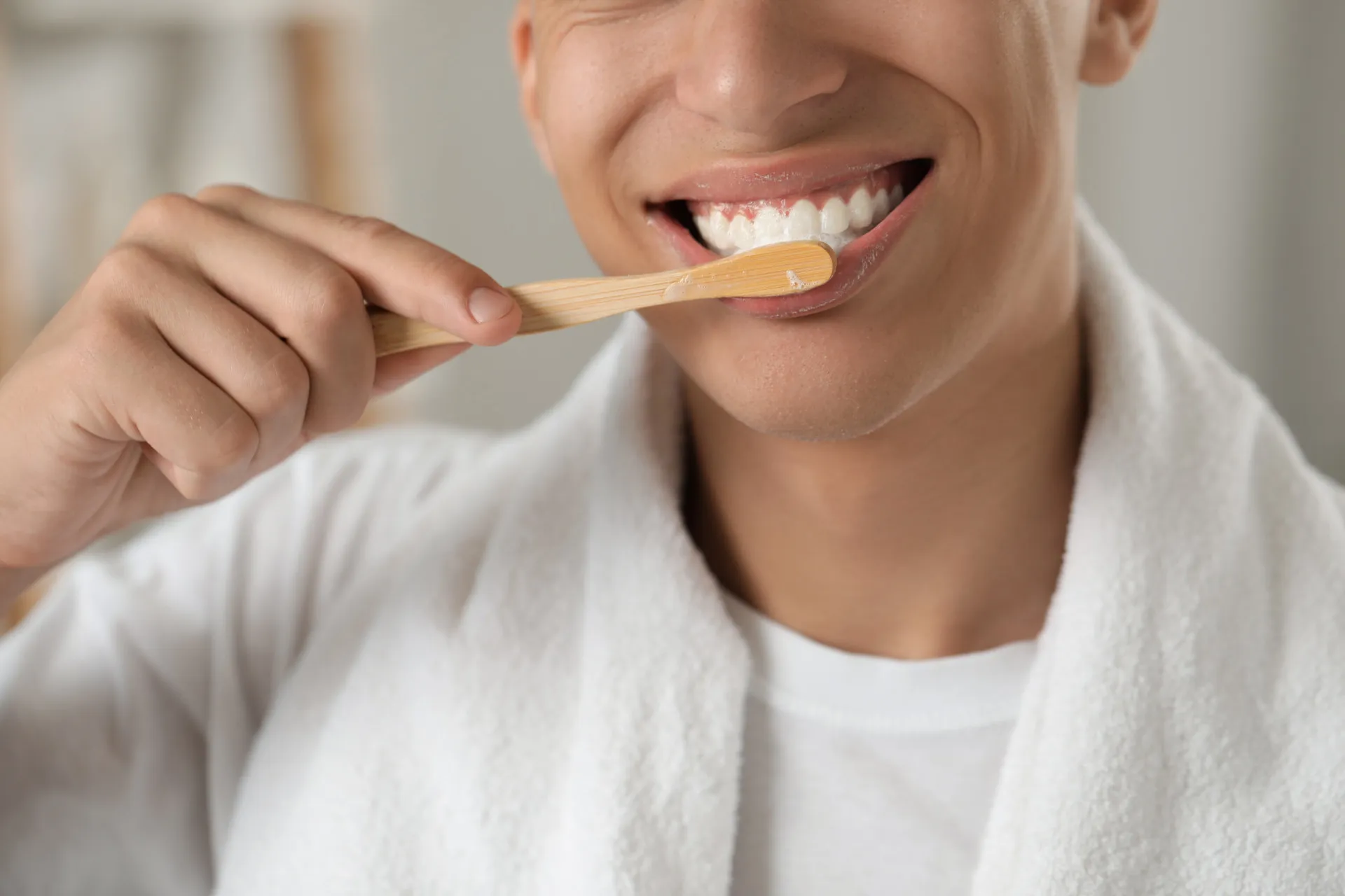 Pessoa escovando os dentes, simbolizando a importância da saúde bucal.