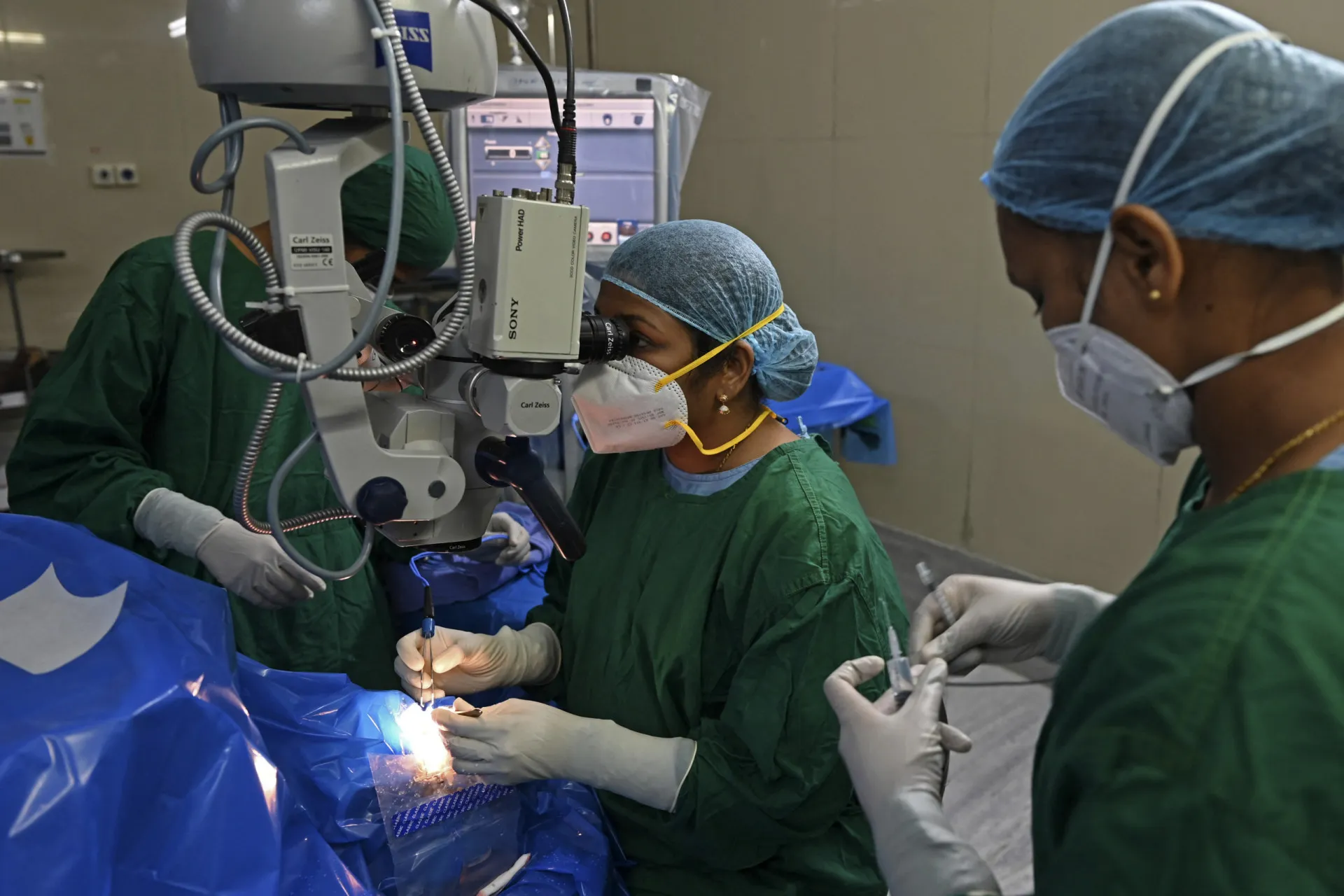 Um cirurgião oftalmológico utilizando um microscópio durante uma operação ocular.