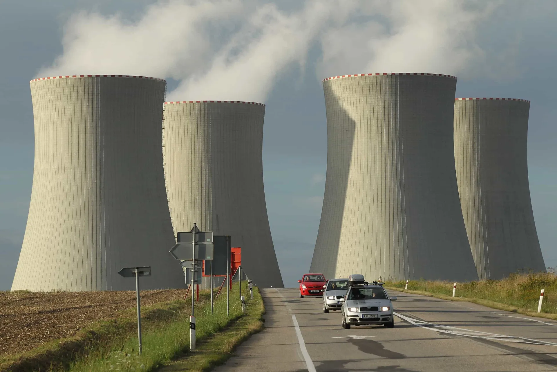 Vista noturna de uma usina nuclear iluminada, simbolizando a geração de eletricidade.