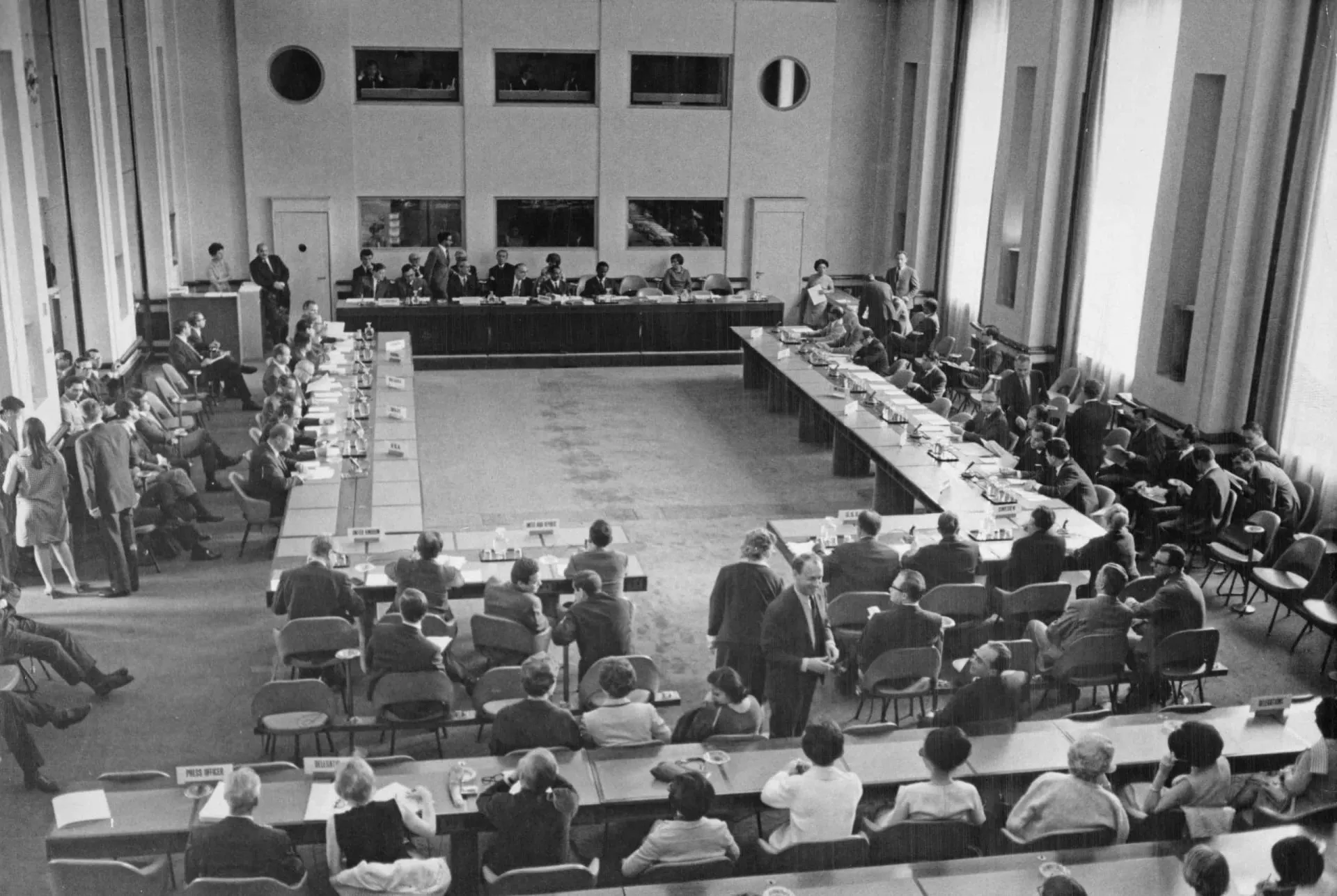 Bandeiras de diversos países em frente a um prédio da ONU, simbolizando o Tratado de Não Proliferação Nuclear.