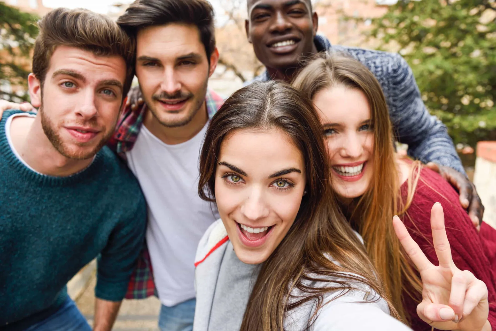 Grupo diversificado de jovens interagindo, representando a experimentação social.