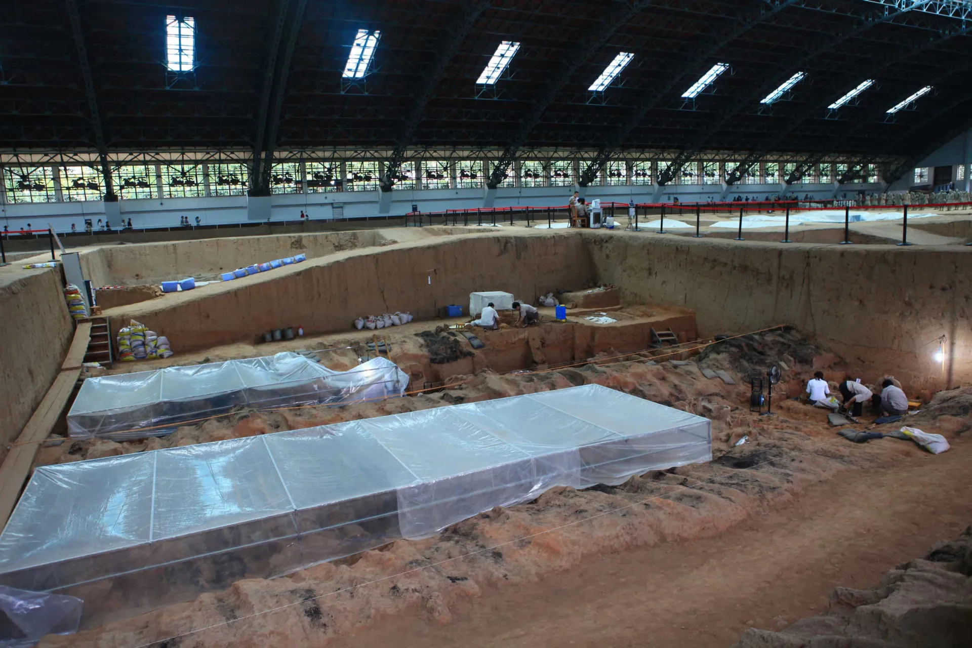 Arqueóloga trabalhando cuidadosamente na restauração de um guerreiro de terracota.