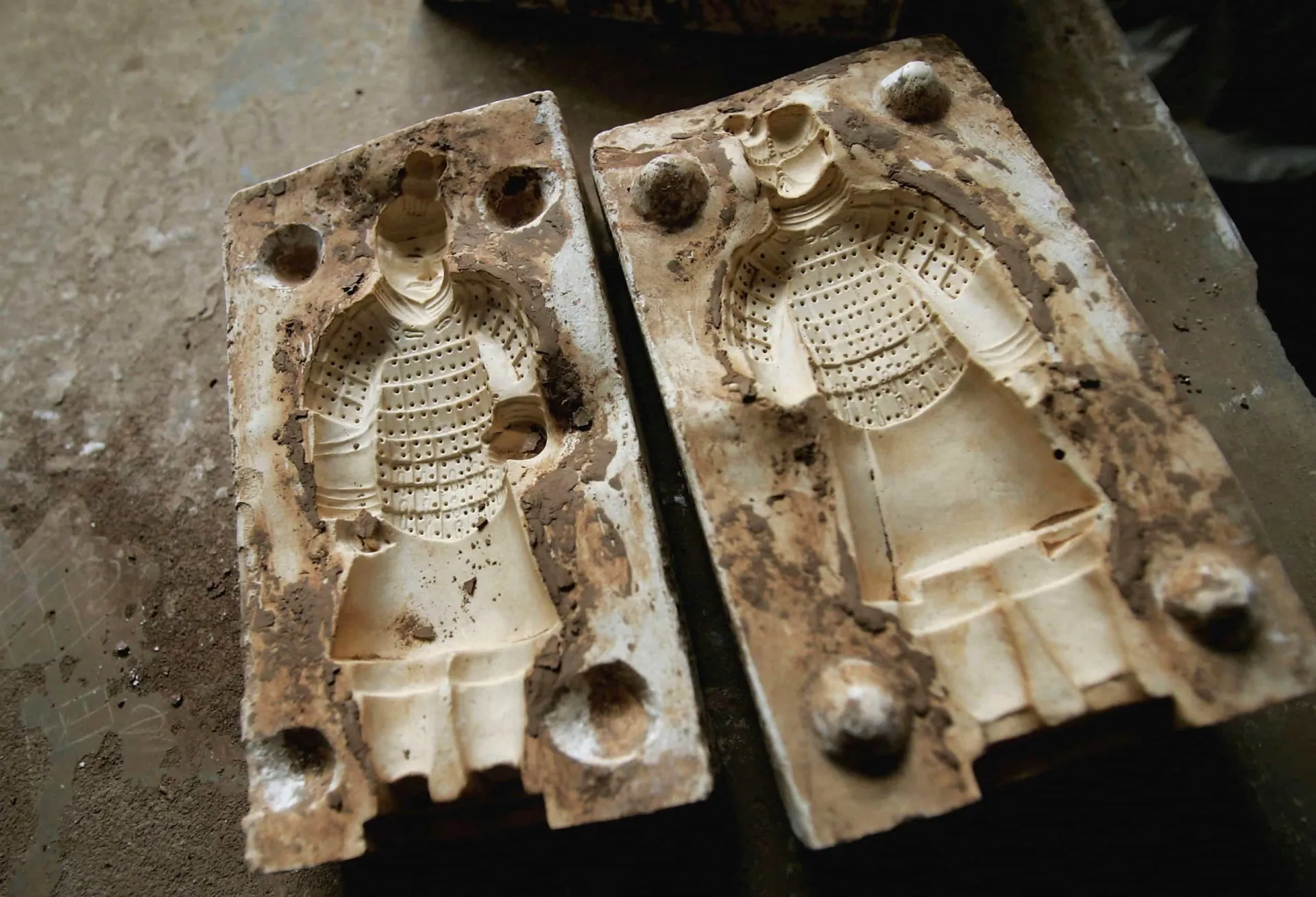 Mãos de um artesão moldando argila em um torno.