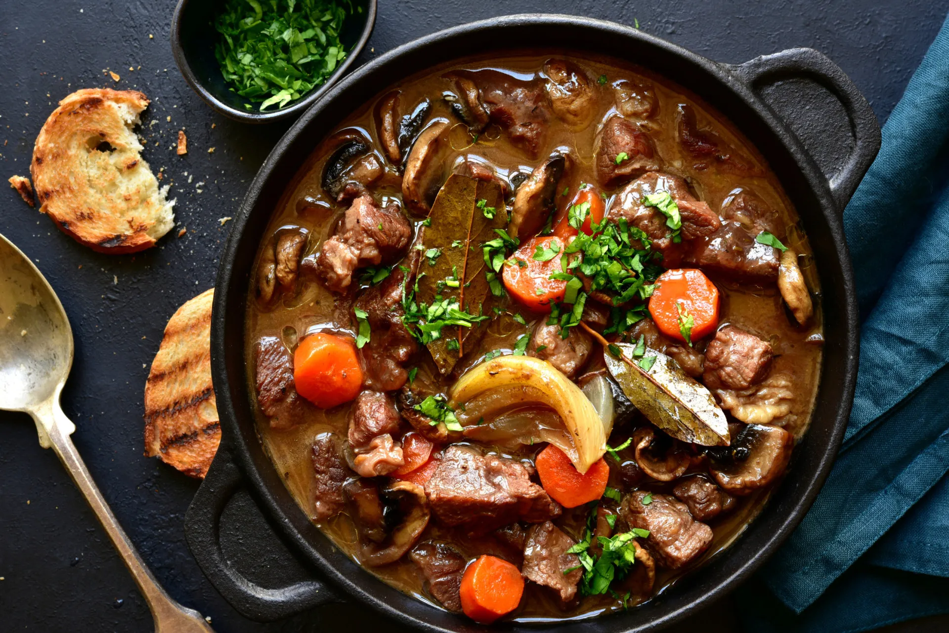 Tigela fumegante de sopa ou ensopado, com vegetais e carne.