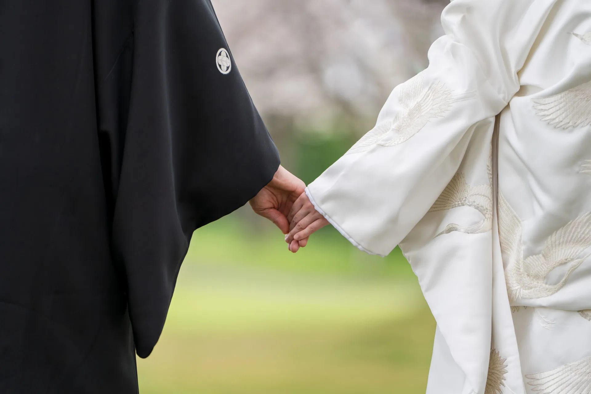 Mãos de um casal sem alianças, representando a queda no número de casamentos.