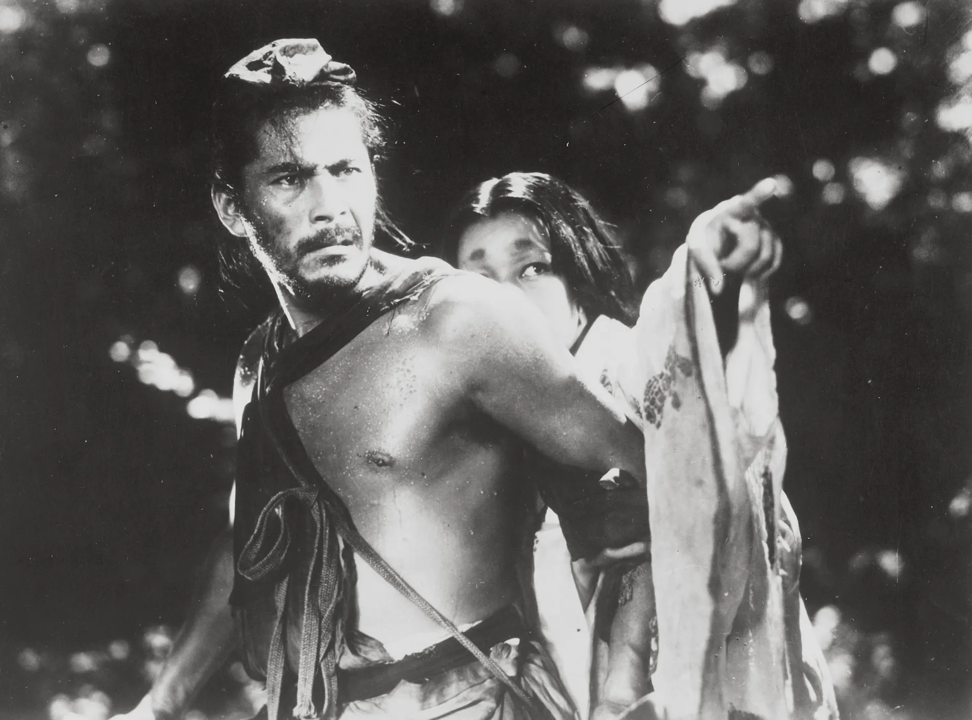 Cena em preto e branco do filme 'Rashomon', com personagens em uma floresta.