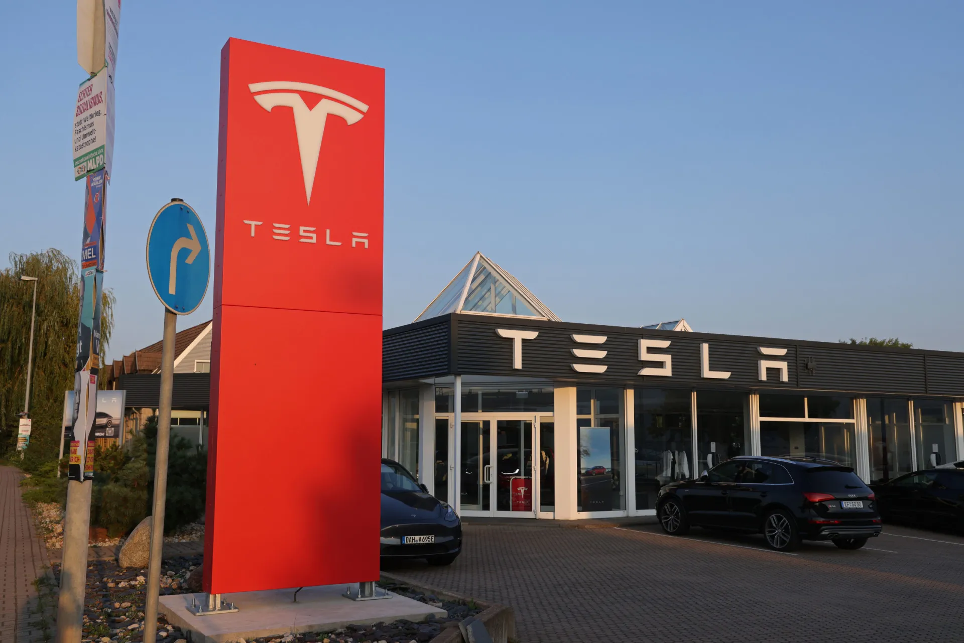 Um carro Tesla vermelho elegante estacionado, com o logotipo da marca em destaque.