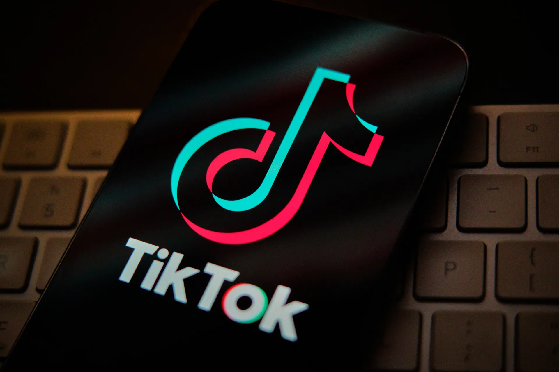O logotipo do TikTok exibido na tela de um celular, com ícones de música e vídeo ao redor.