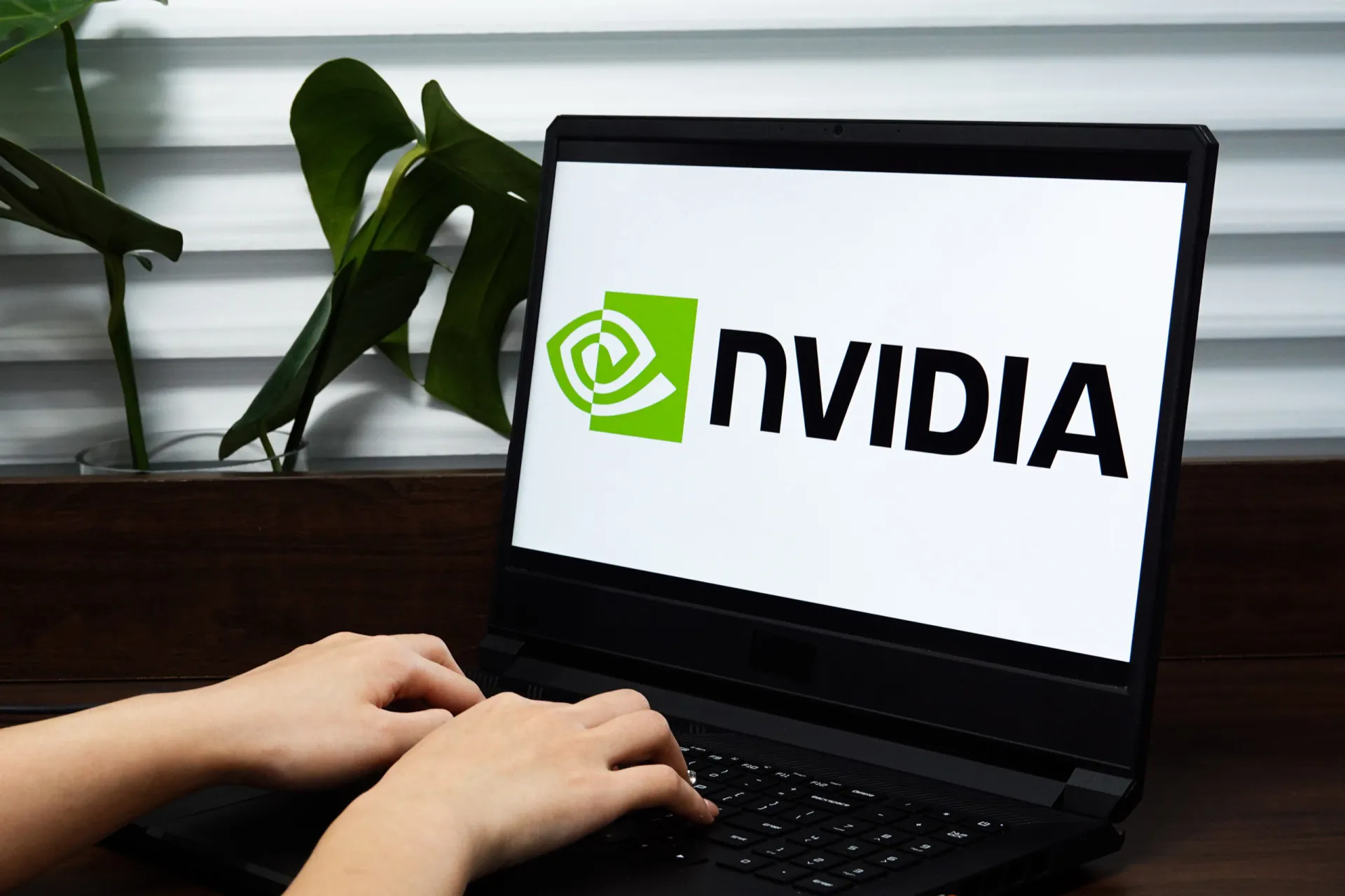 Logo da Nvidia em destaque sobre uma placa de circuito eletrônico com luzes verdes.
