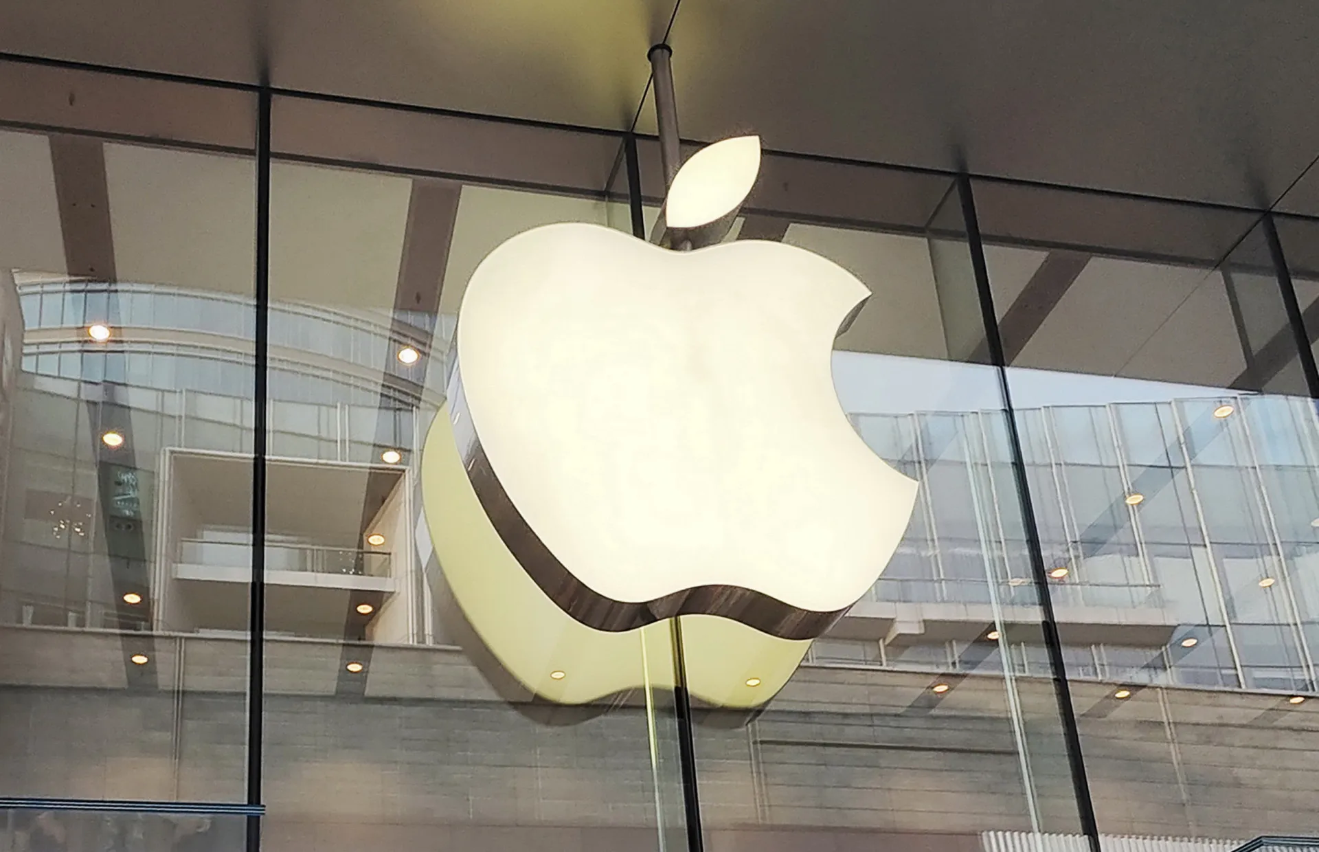 O icônico logotipo da maçã mordida da Apple brilhando na frente de uma loja.