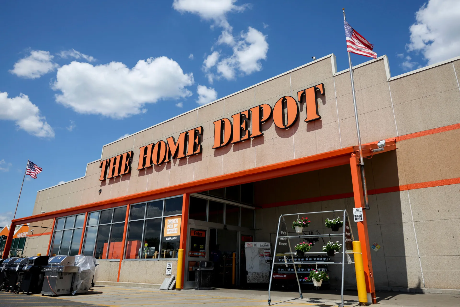 Corredor de uma loja Home Depot com prateleiras cheias de ferramentas e materiais de construção.
