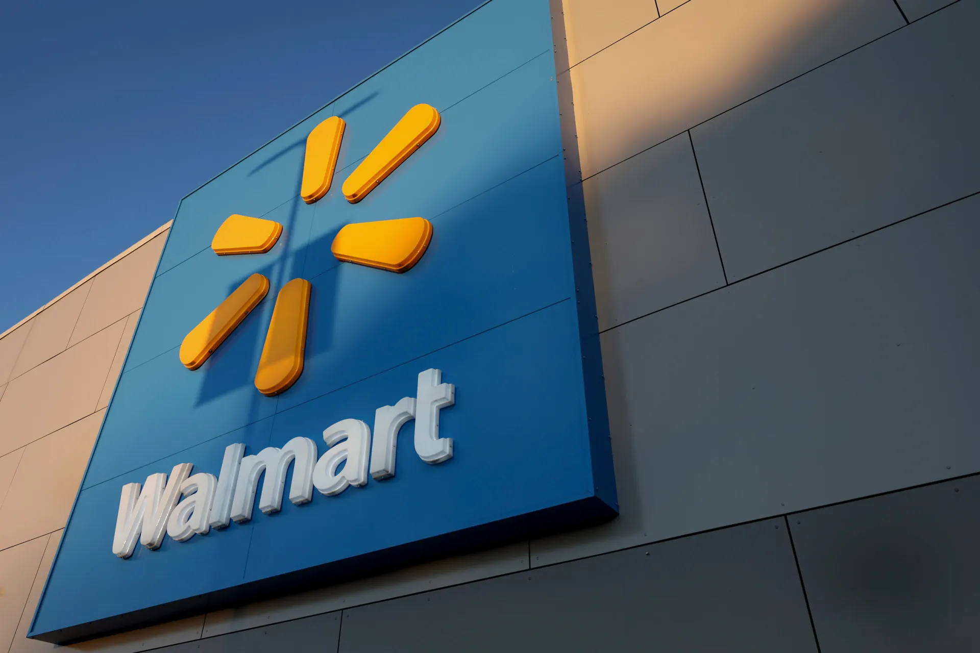 A fachada de uma grande loja do Walmart, com seu logotipo azul e amarelo em destaque.
