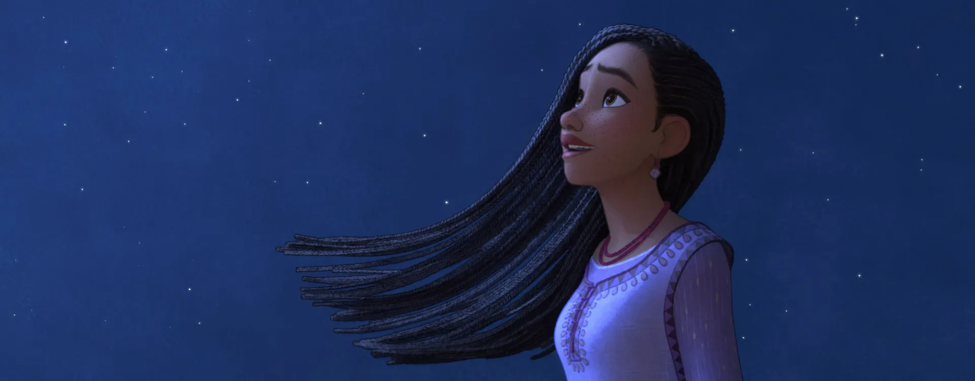 Asha, a protagonista de 'Wish', olhando para uma estrela mágica no céu noturno.