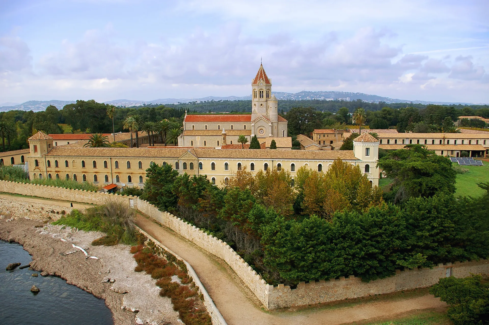 O antigo mosteiro da Ilha de Saint-Honorat, cercado por vegetação e pelo mar.