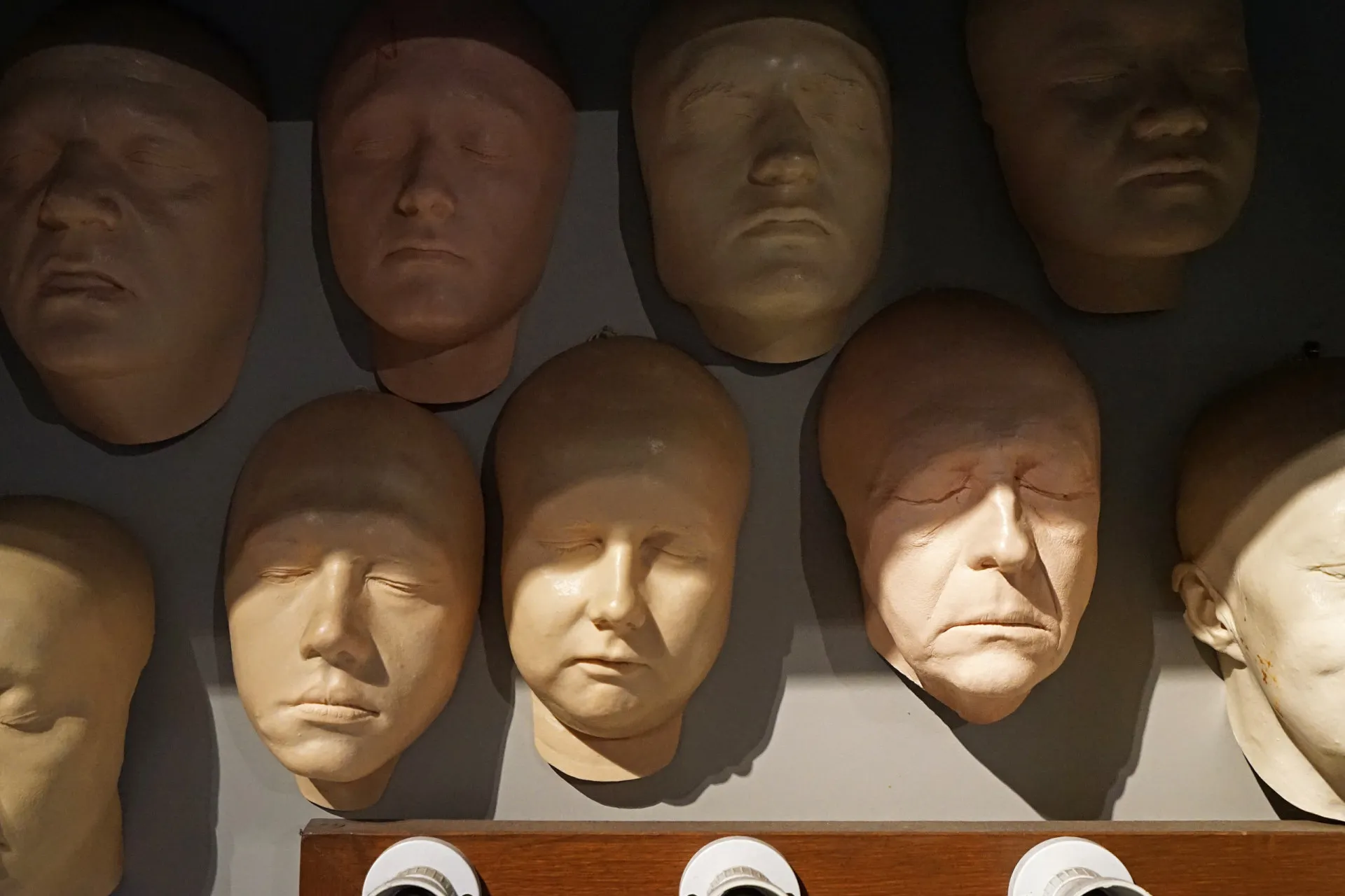 Uma pessoa usando uma máscara realista, olhando para a câmera de forma sinistra e anônima.