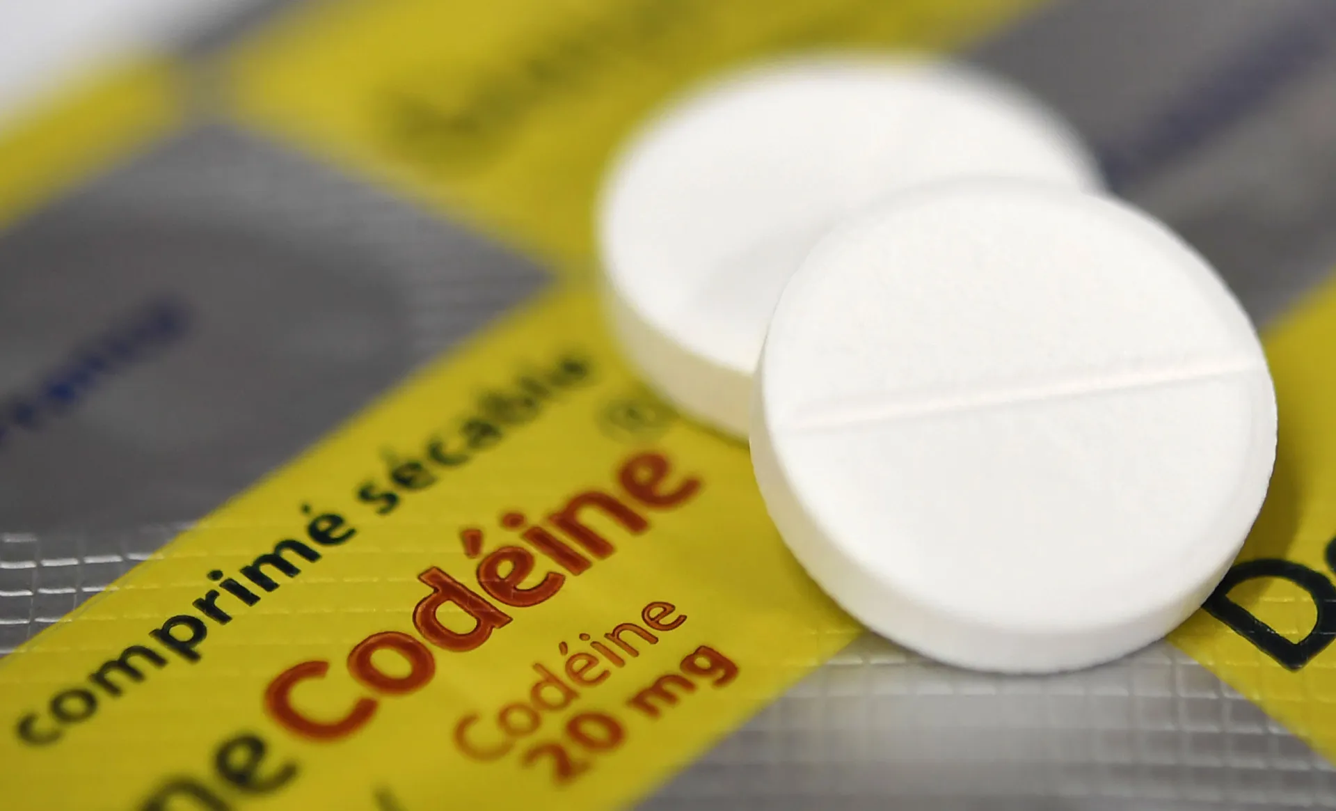 Uma pessoa com expressão de dor, simbolizando a busca desesperada por alívio que pode levar à overdose de codeína.