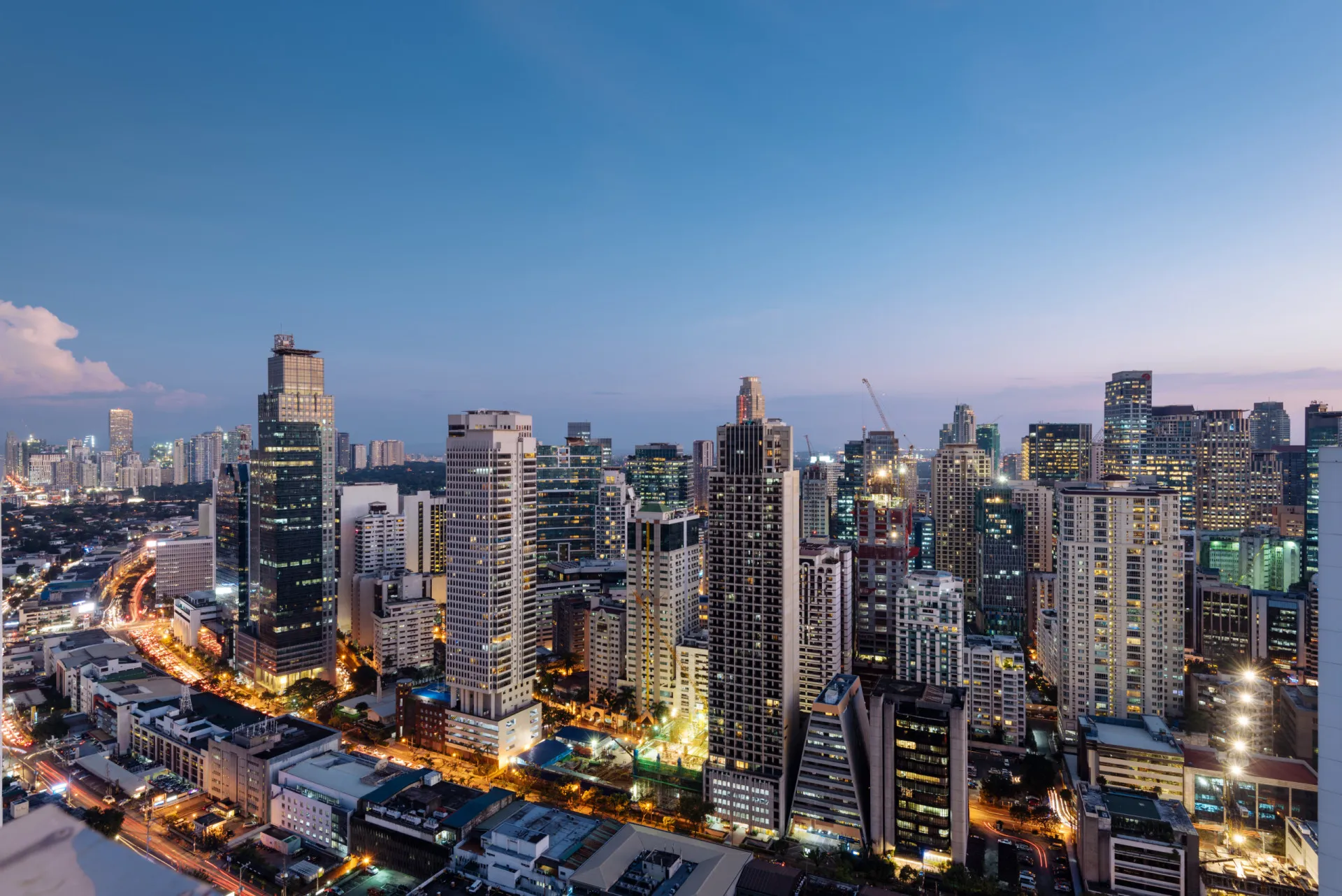 Rua extremamente lotada em Manila, Filipinas, com muitas pessoas, veículos e barracas.