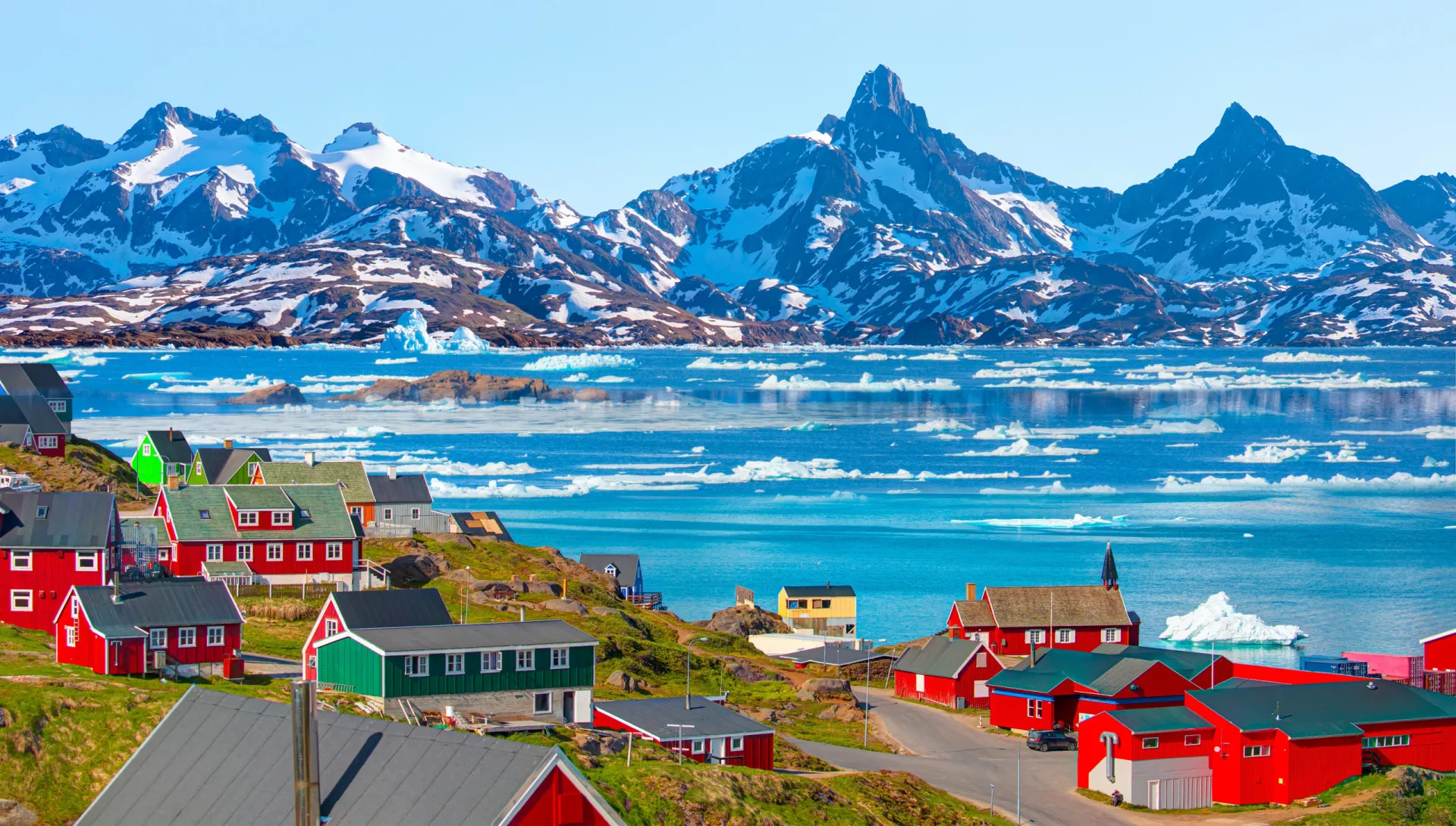 Paisagem vasta e gelada da Groenlândia, com icebergs e montanhas de neve.