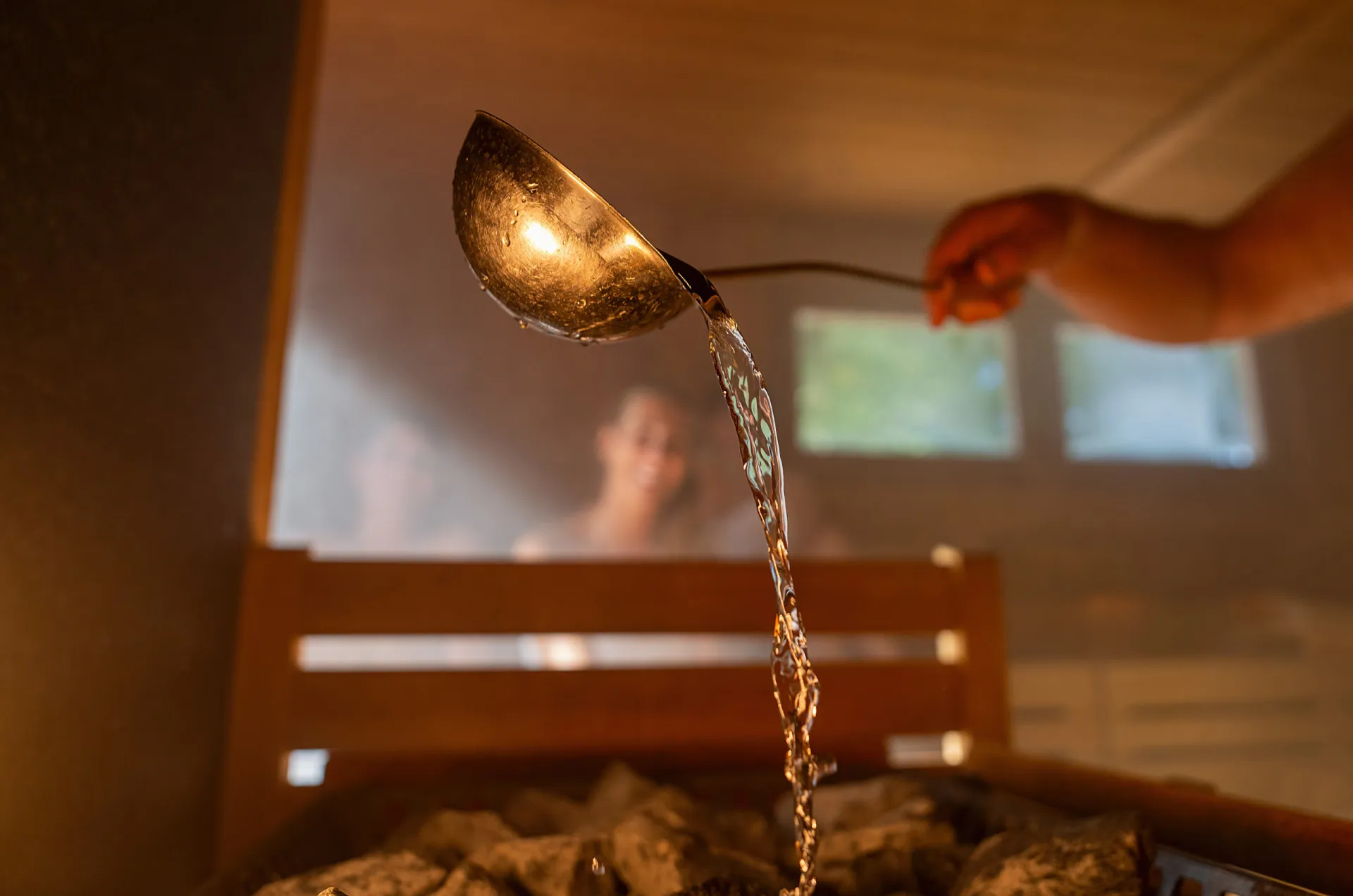 Interior de uma sauna finlandesa tradicional de madeira, com um balde e concha.