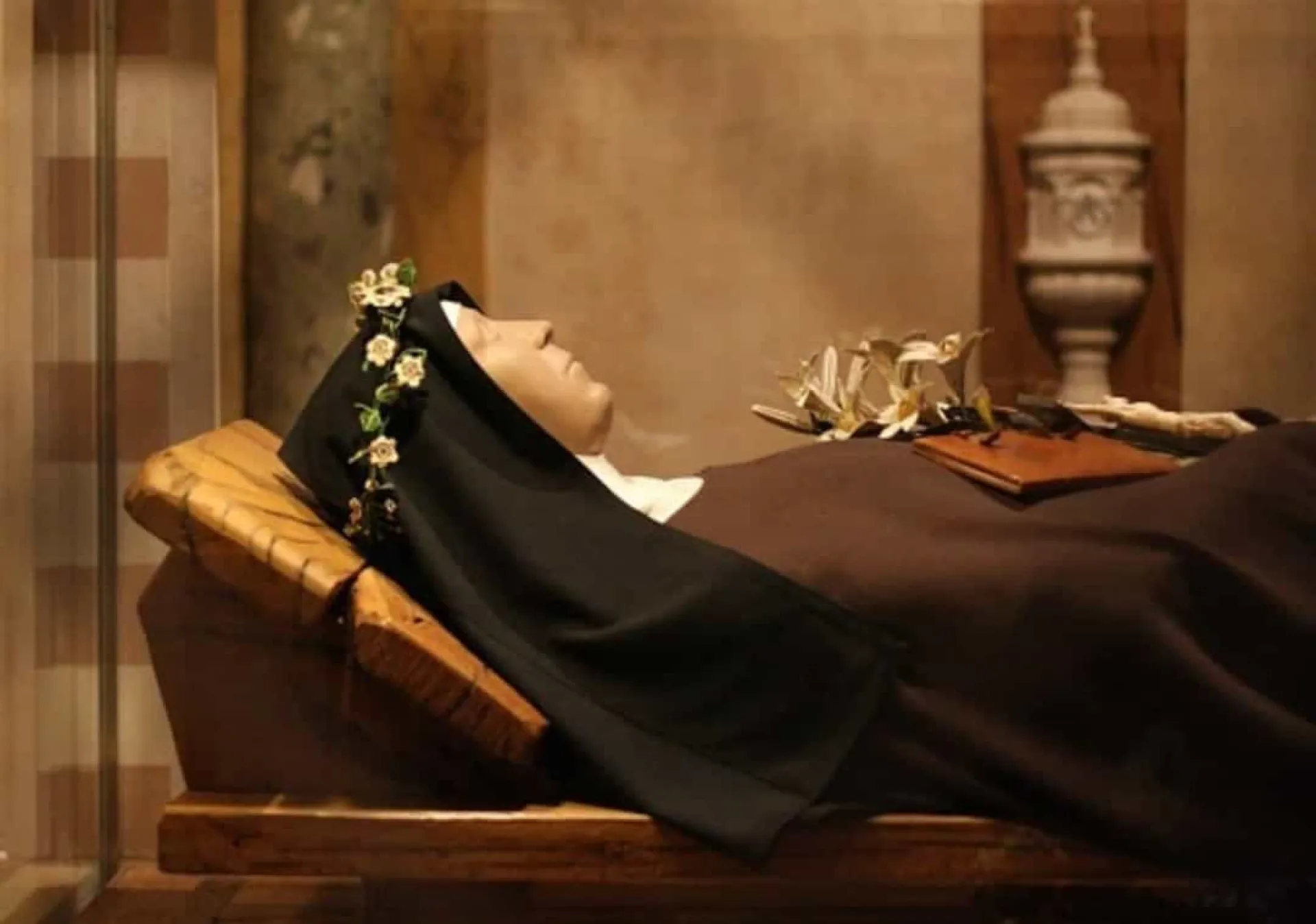 Rosto de uma estátua de santa com feições serenas, evocando a paz atribuída aos incorruptos.
