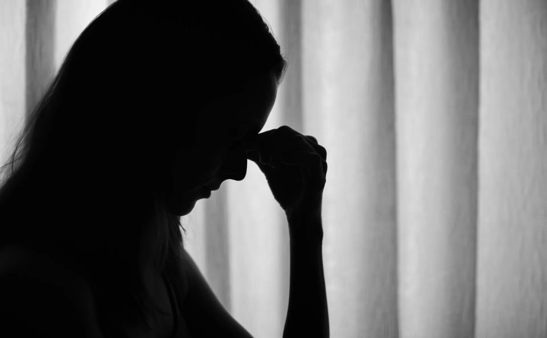 Uma pessoa escondendo as mãos, com uma expressão de constrangimento e vergonha.