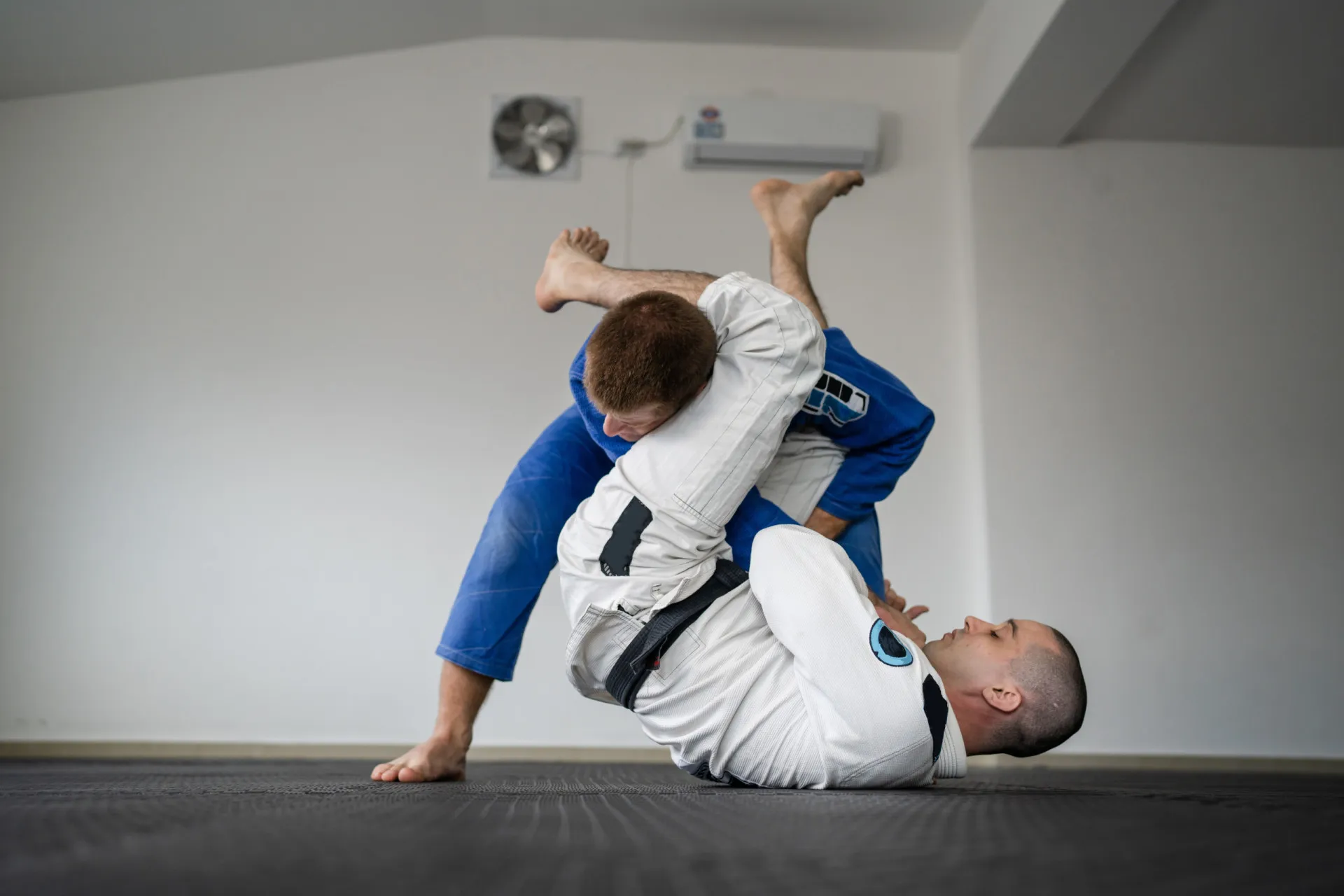 Lutadores de jiu-jitsu em uma posição de alavanca, demonstrando o princípio de usar a força do oponente.