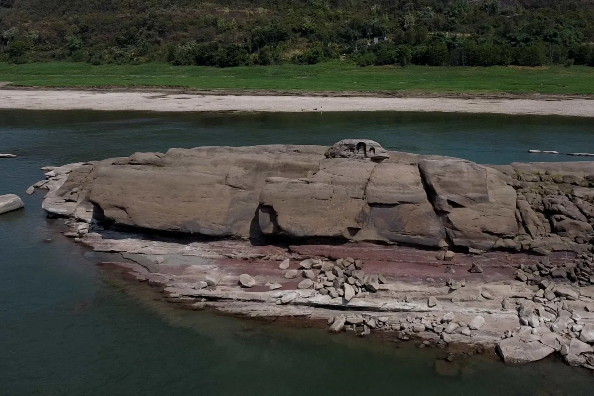 Três estátuas budistas esculpidas em uma grande rocha que emergiu no meio do Rio Yangtzé.