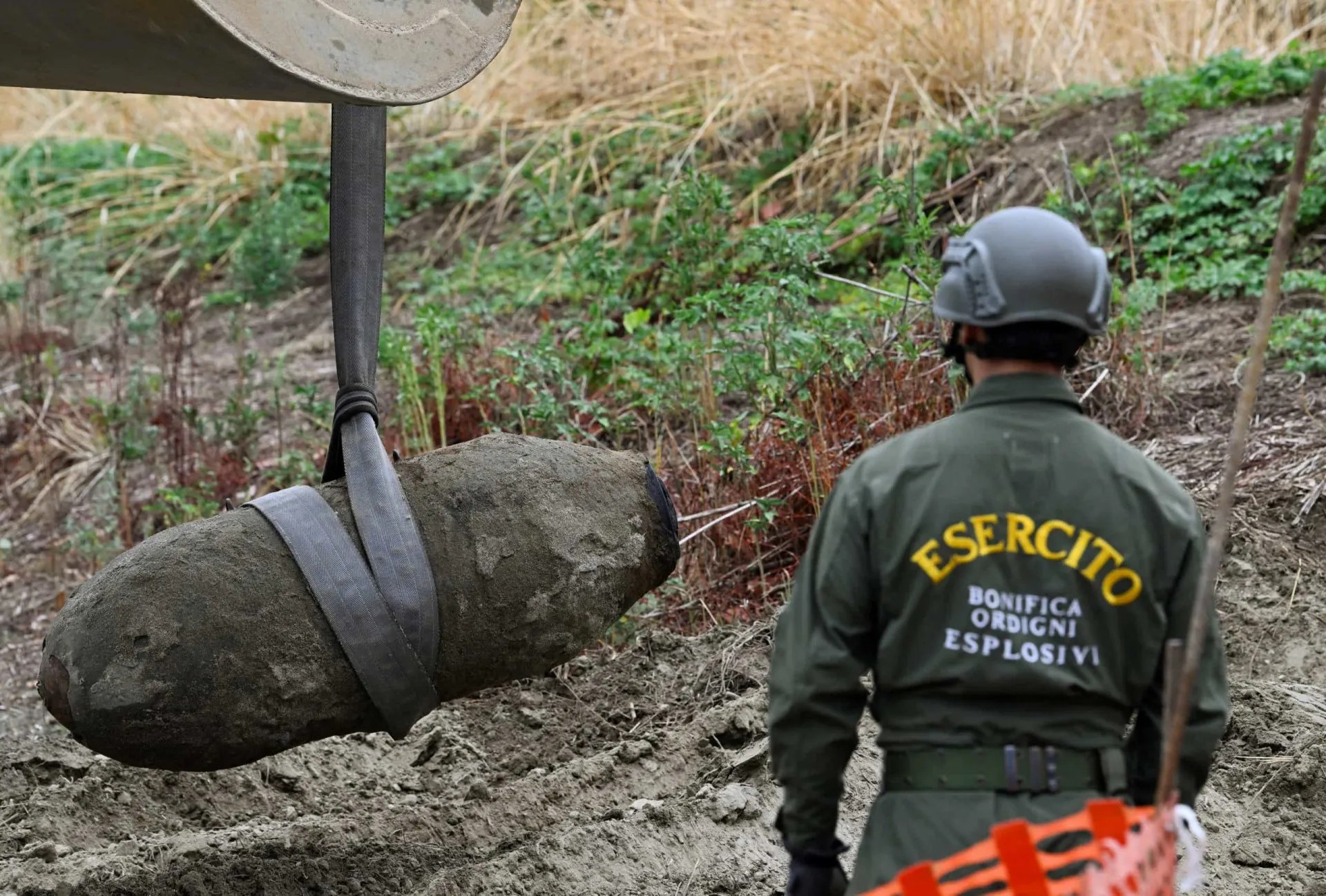 Militar italiano ao lado de uma enorme bomba não detonada, encontrada no Rio Pó.