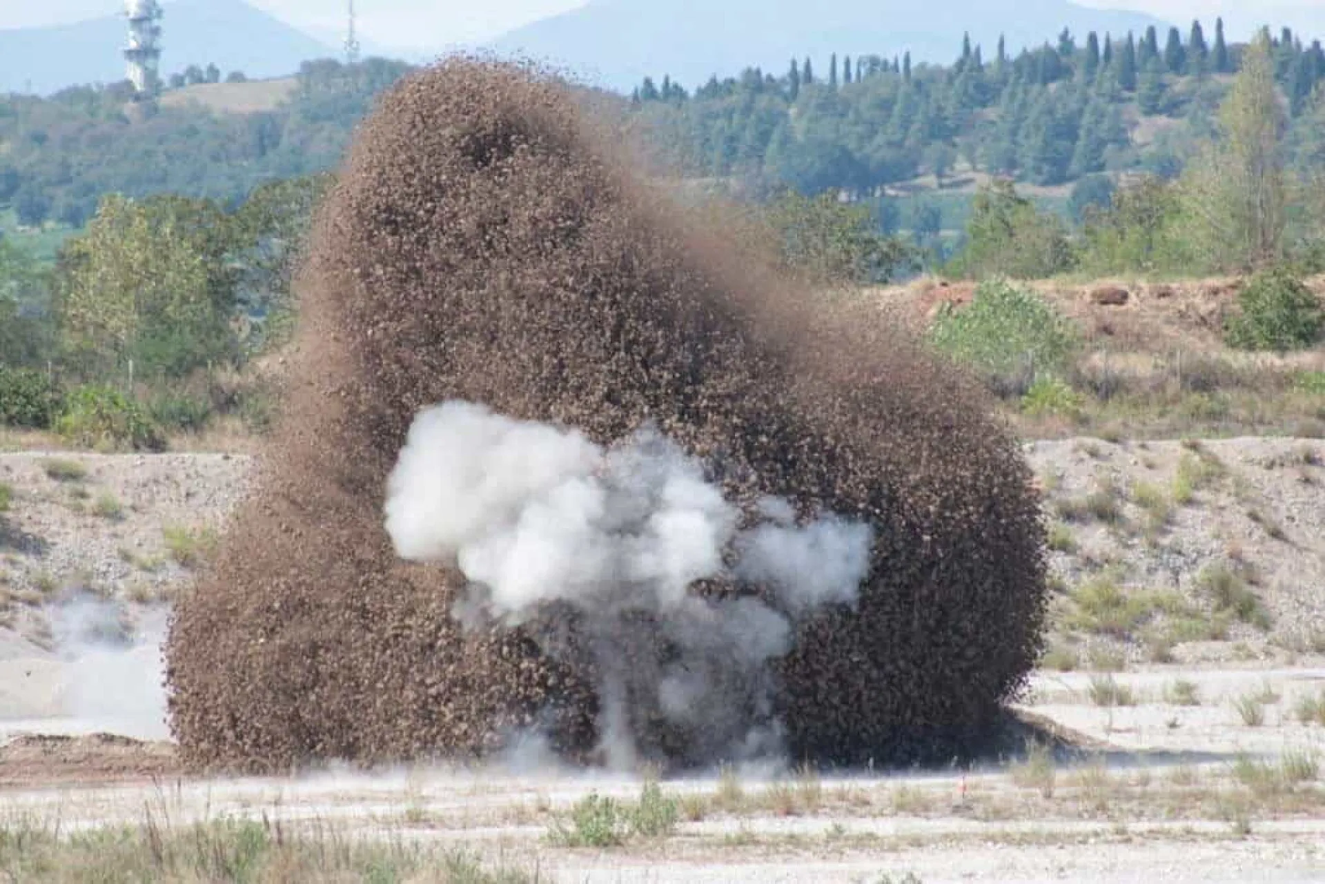Momento da explosão controlada da bomba da Segunda Guerra Mundial, levantando uma nuvem de terra e fumaça.
