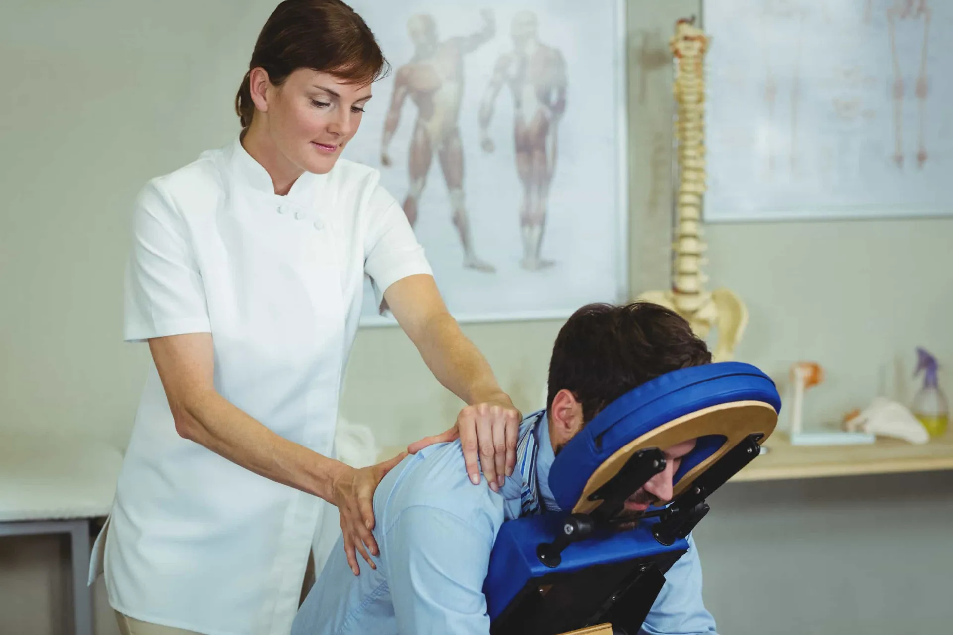 Paciente em uma cama de hospital recebendo uma massagem nas mãos de um terapeuta.