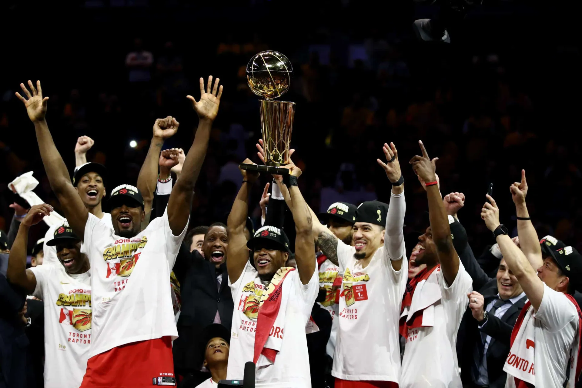 Time de basquete comemorando uma vitória, todos se abraçando.